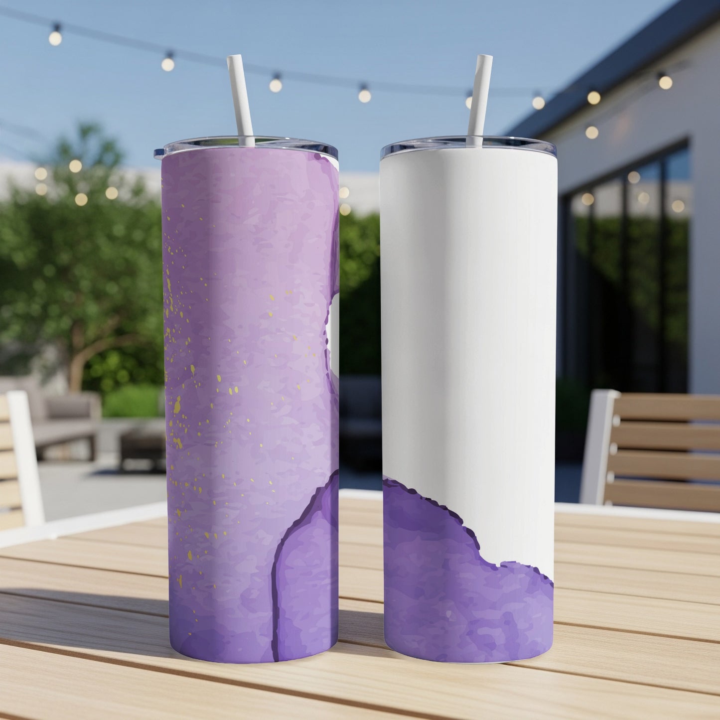 Two tumblers with purple watercolor design and straws on a table.