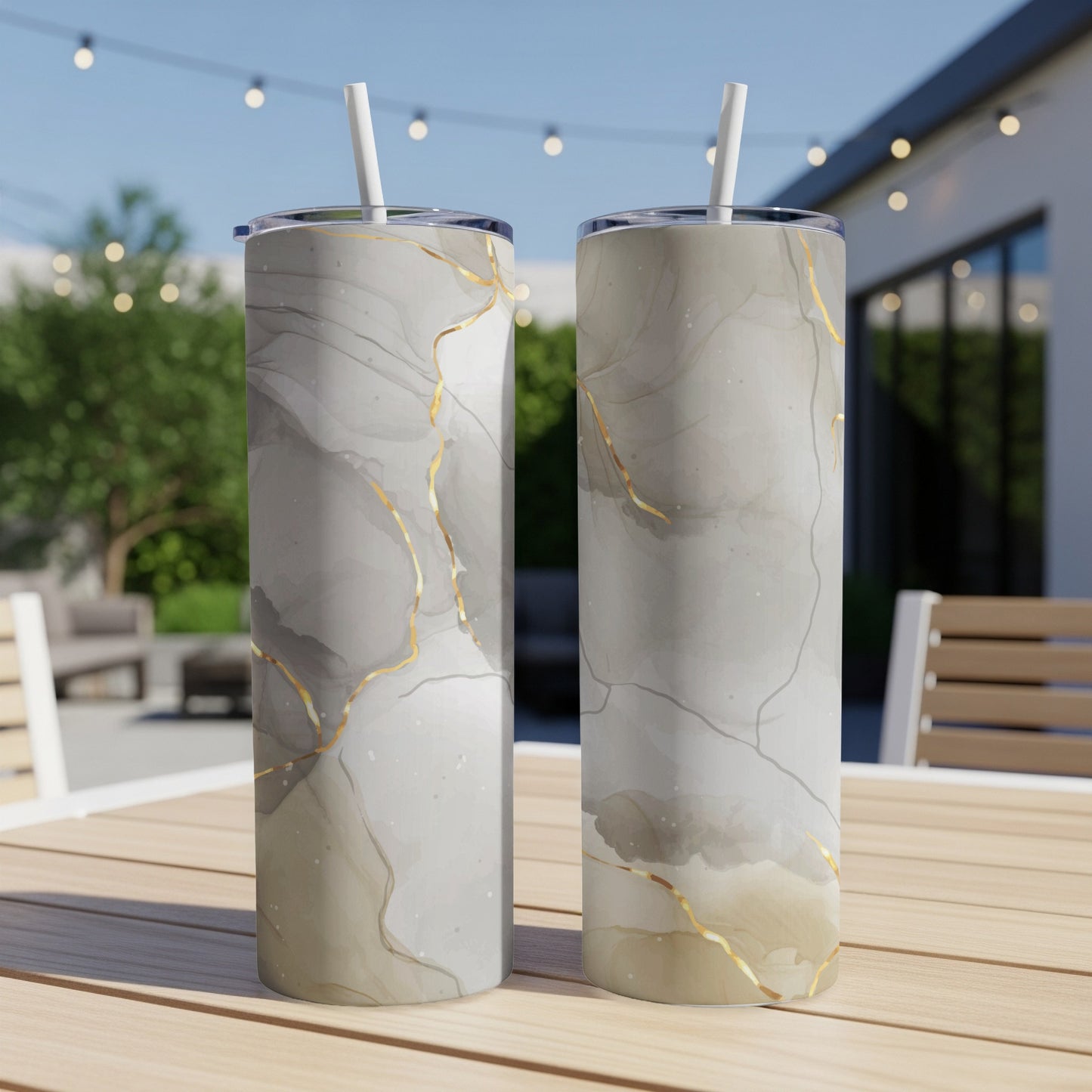 Two tall tumblers with marble and gold crackle pattern on a wooden table.