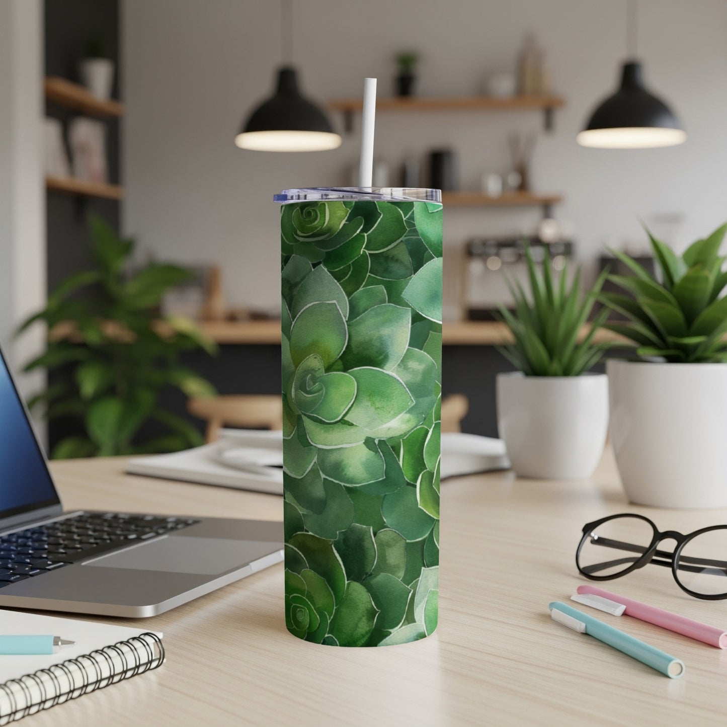 Green succulent pattern on a white insulated tumbler with a straw.