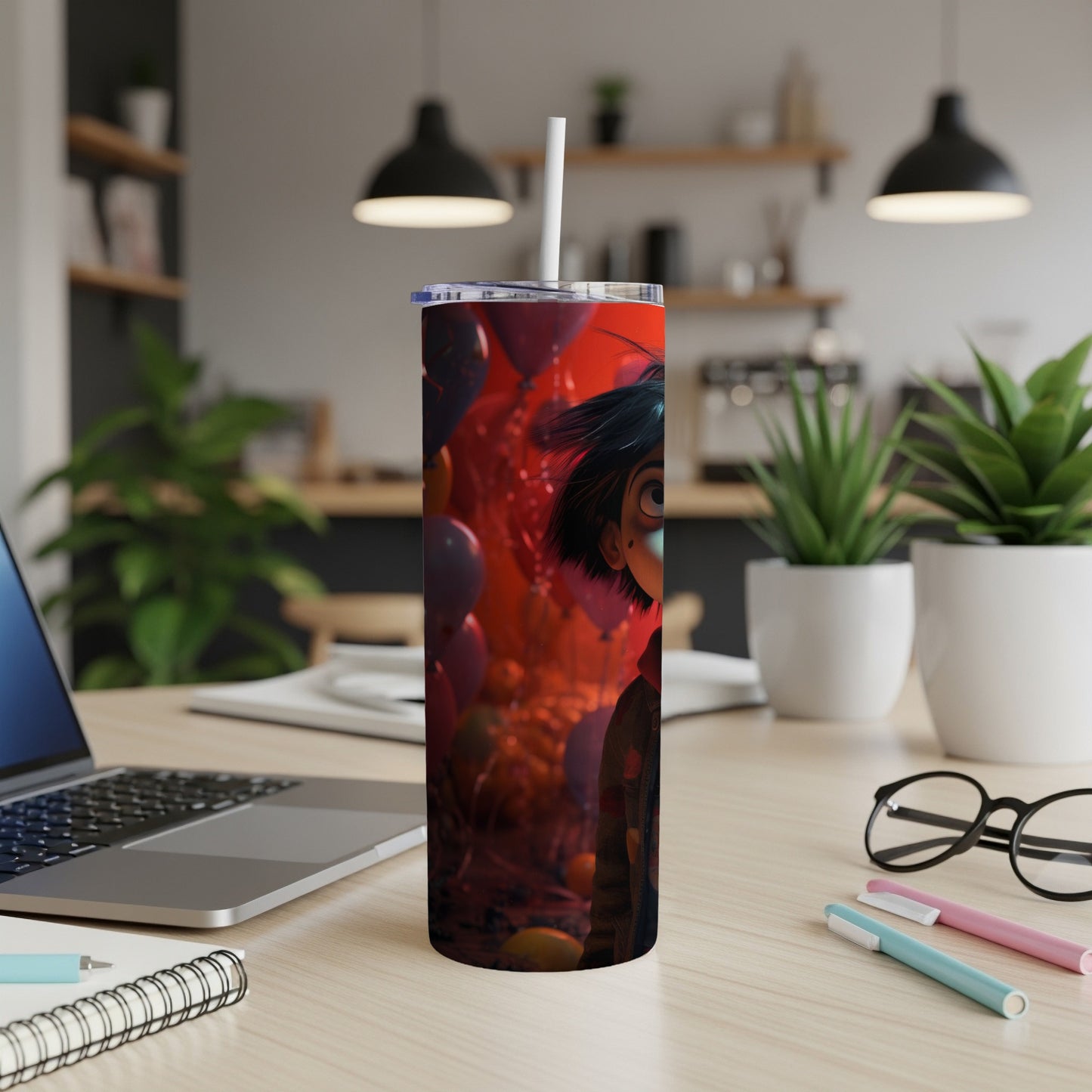 Tall tumbler with cartoon character and red balloons on a desk with laptop.