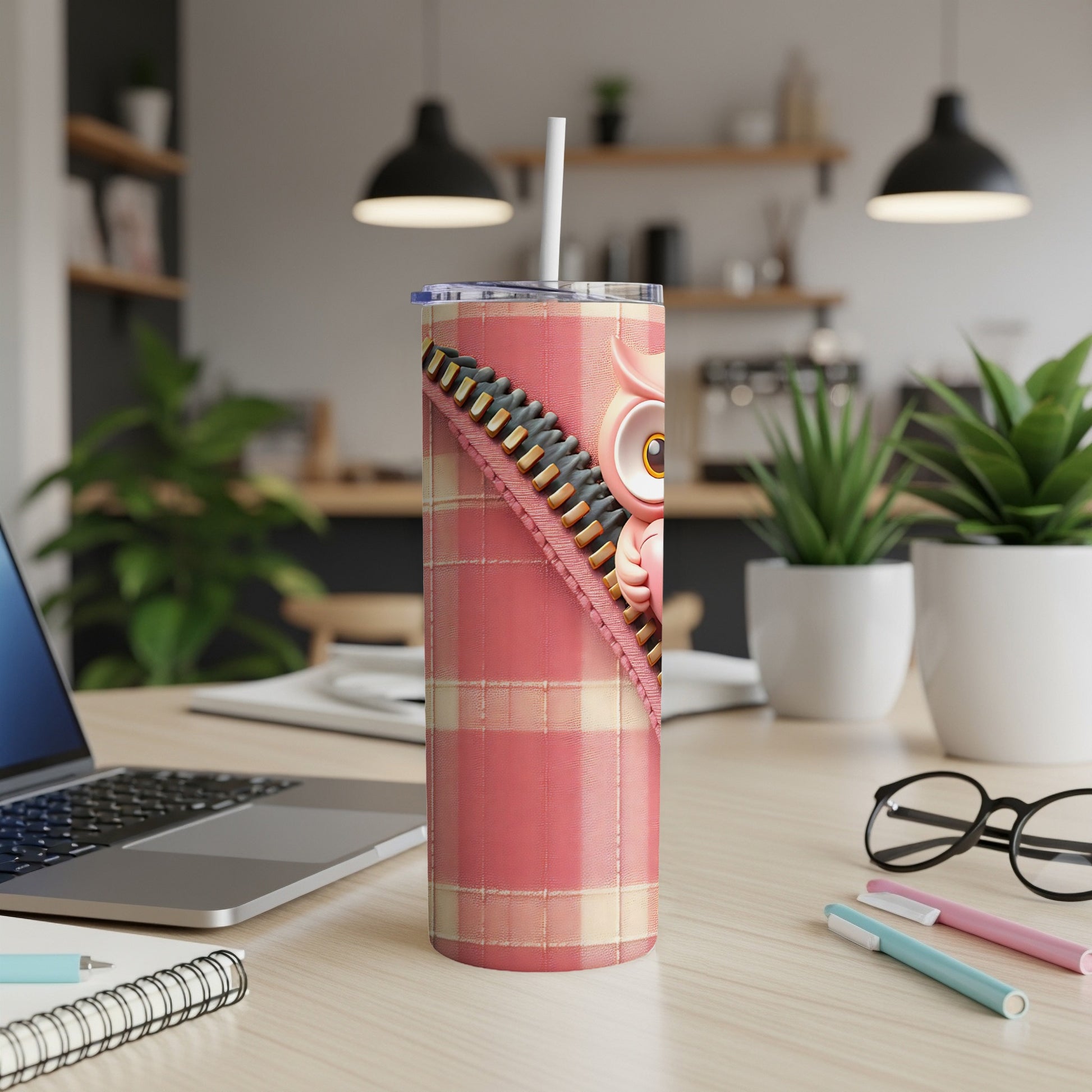 Pink owl tumbler with plaid design and straw on a desk.