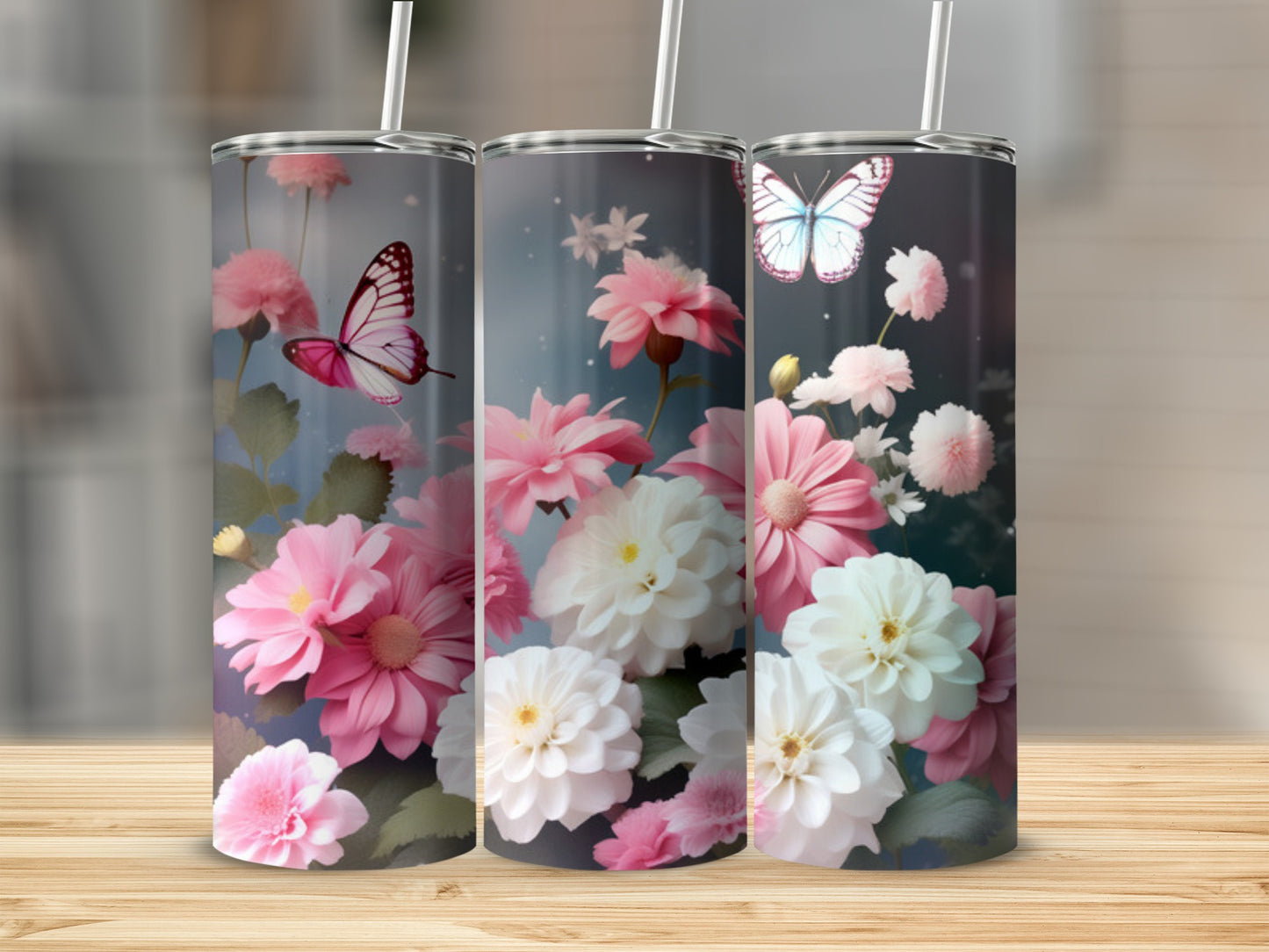 Three tumblers with floral and butterfly designs on a wooden surface.