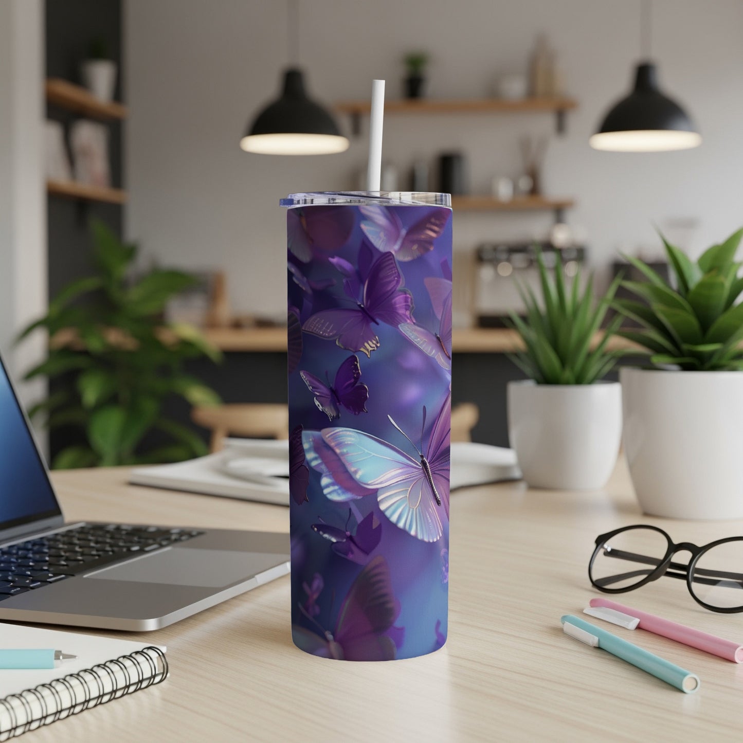 Purple butterflies on a blue background adorn a tall, slender tumbler with a straw.