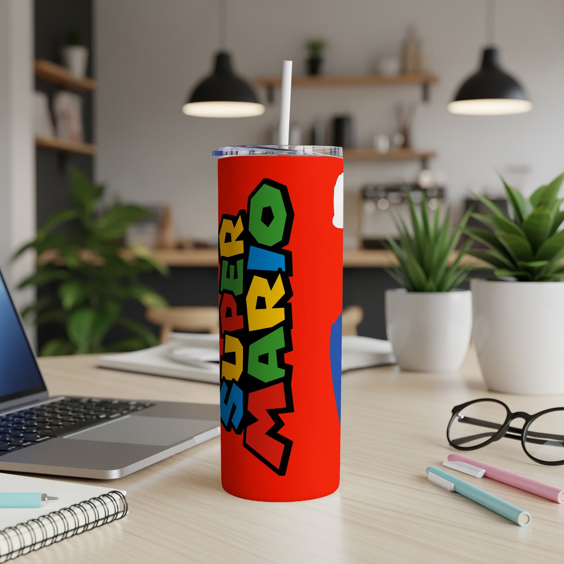 Red Super Mario tumbler with straw on a desk.