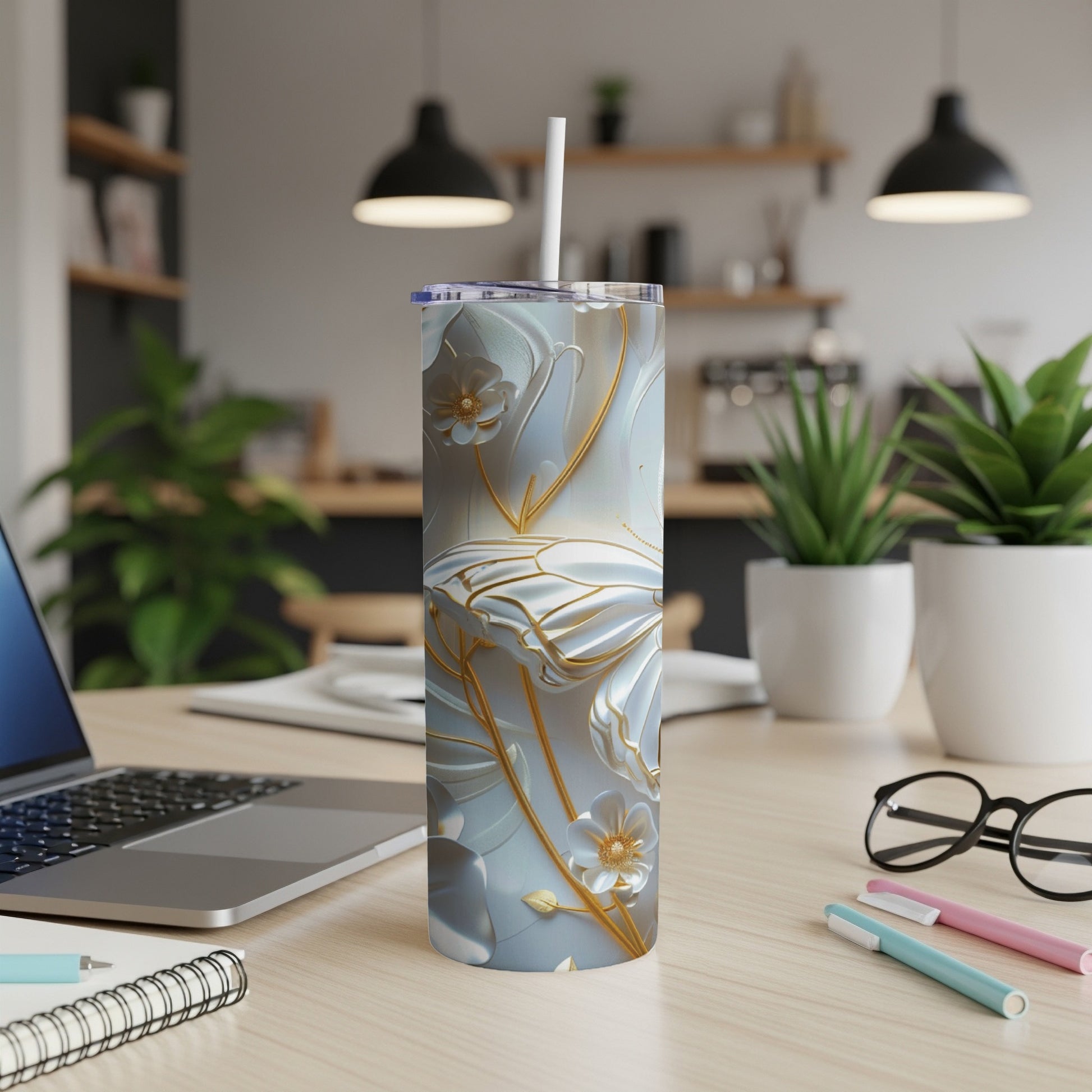 White tumbler with gold butterfly and floral design on desk.