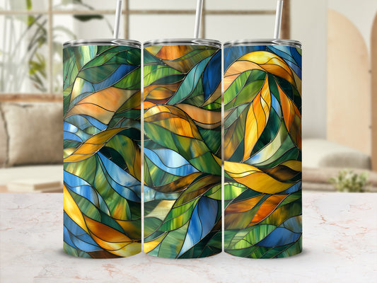Three abstract stained glass pattern tumblers with straws on a counter.
