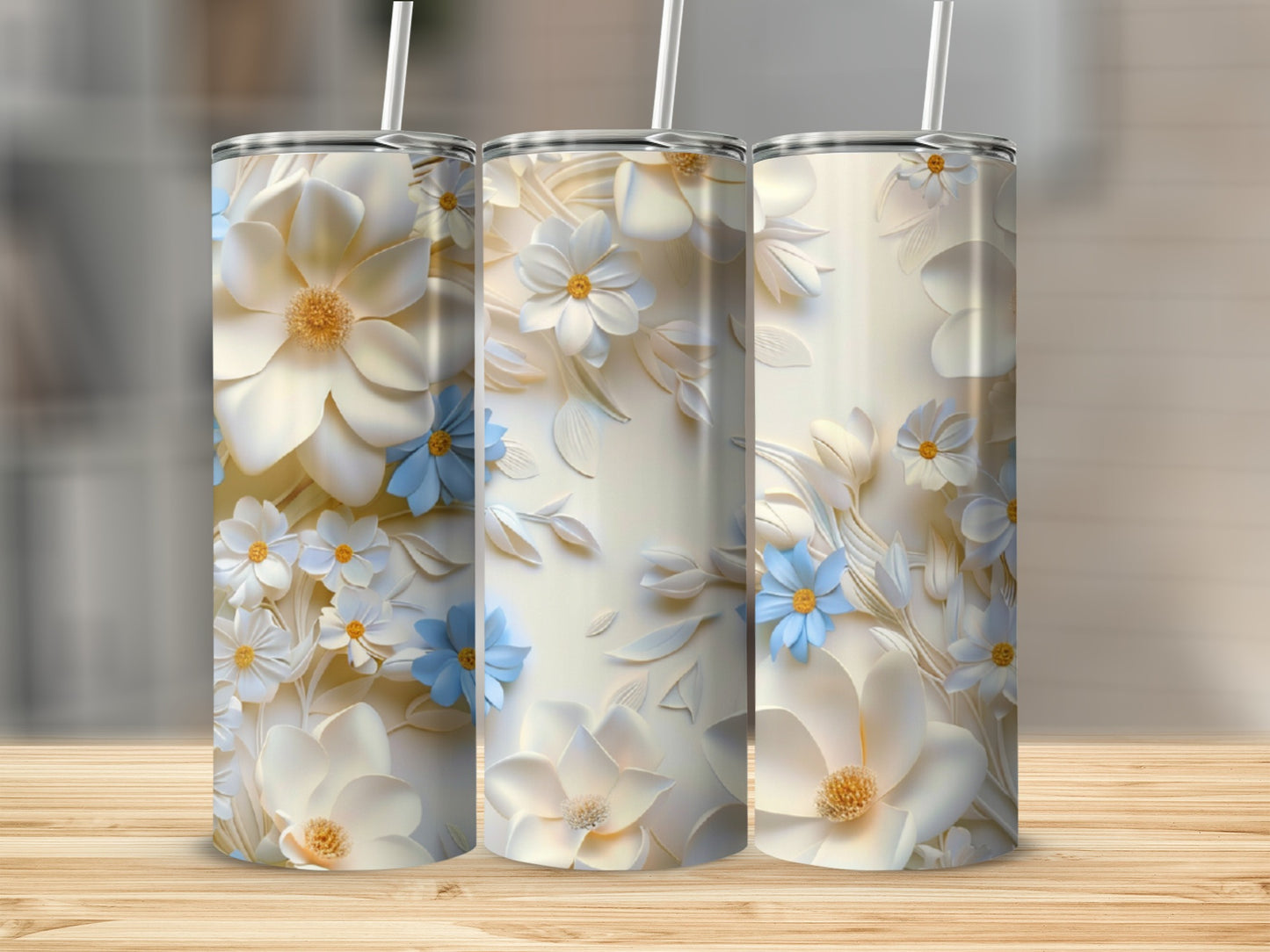 Three white tumblers with a floral embossed design in blue and cream.