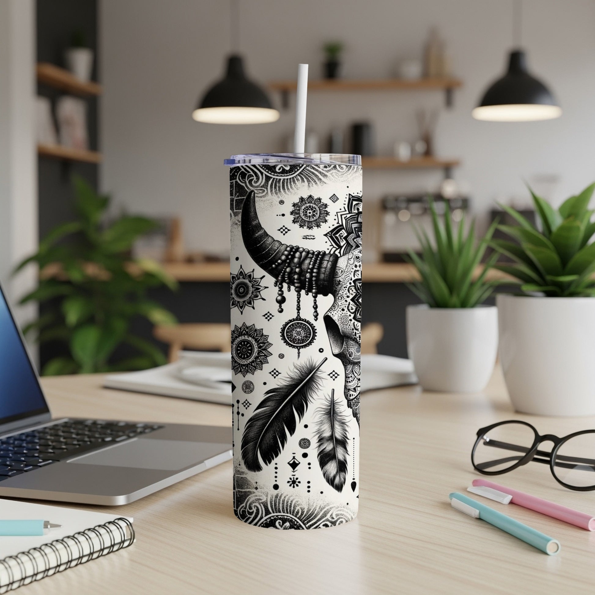 Black and white tribal skull and feather design on a tumbler with straw.