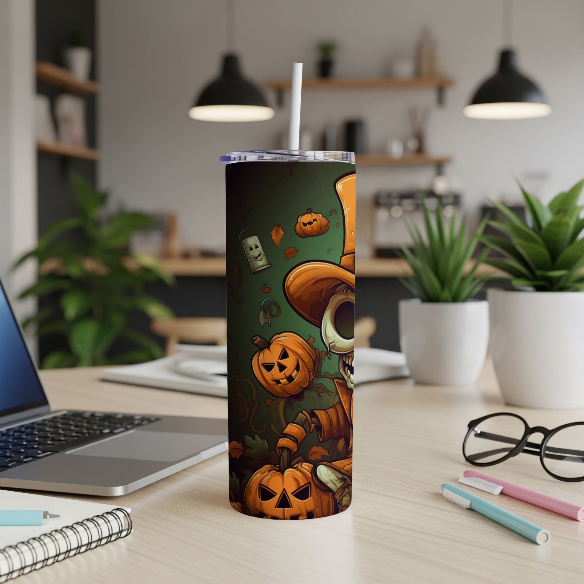 Halloween tumbler with skeleton and pumpkins design on a desk.