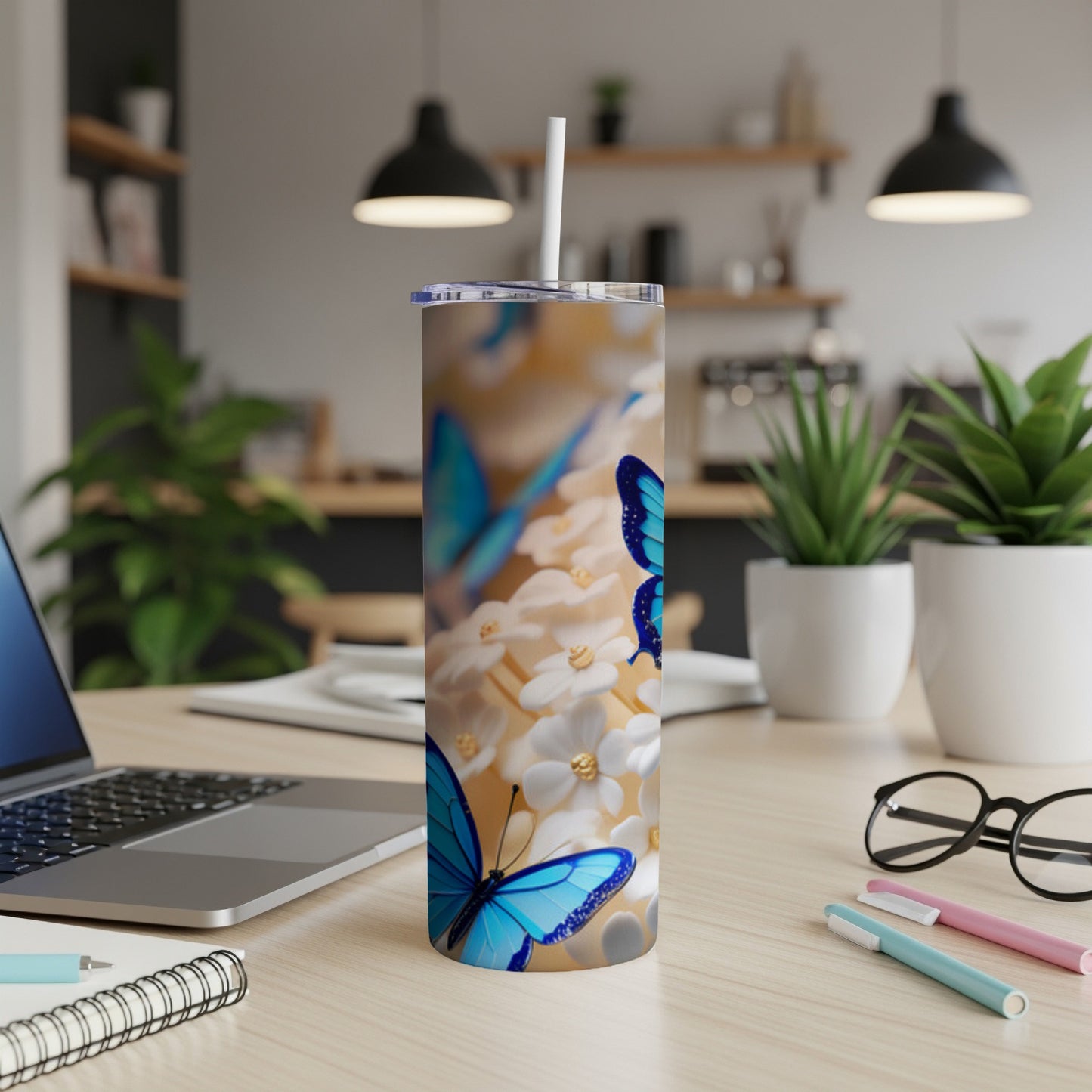 Blue butterflies on a floral background wrap around a tumbler with a straw.