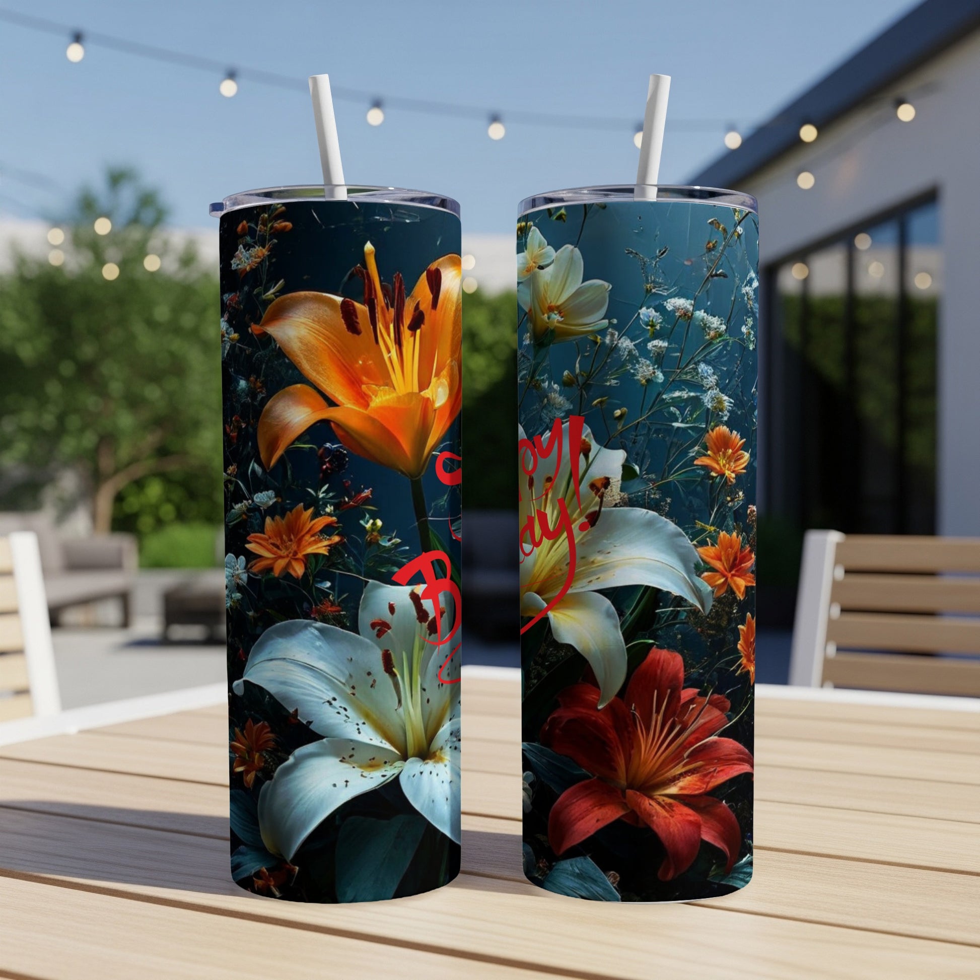 Two tumblers with floral design and text in a dark, outdoor setting.