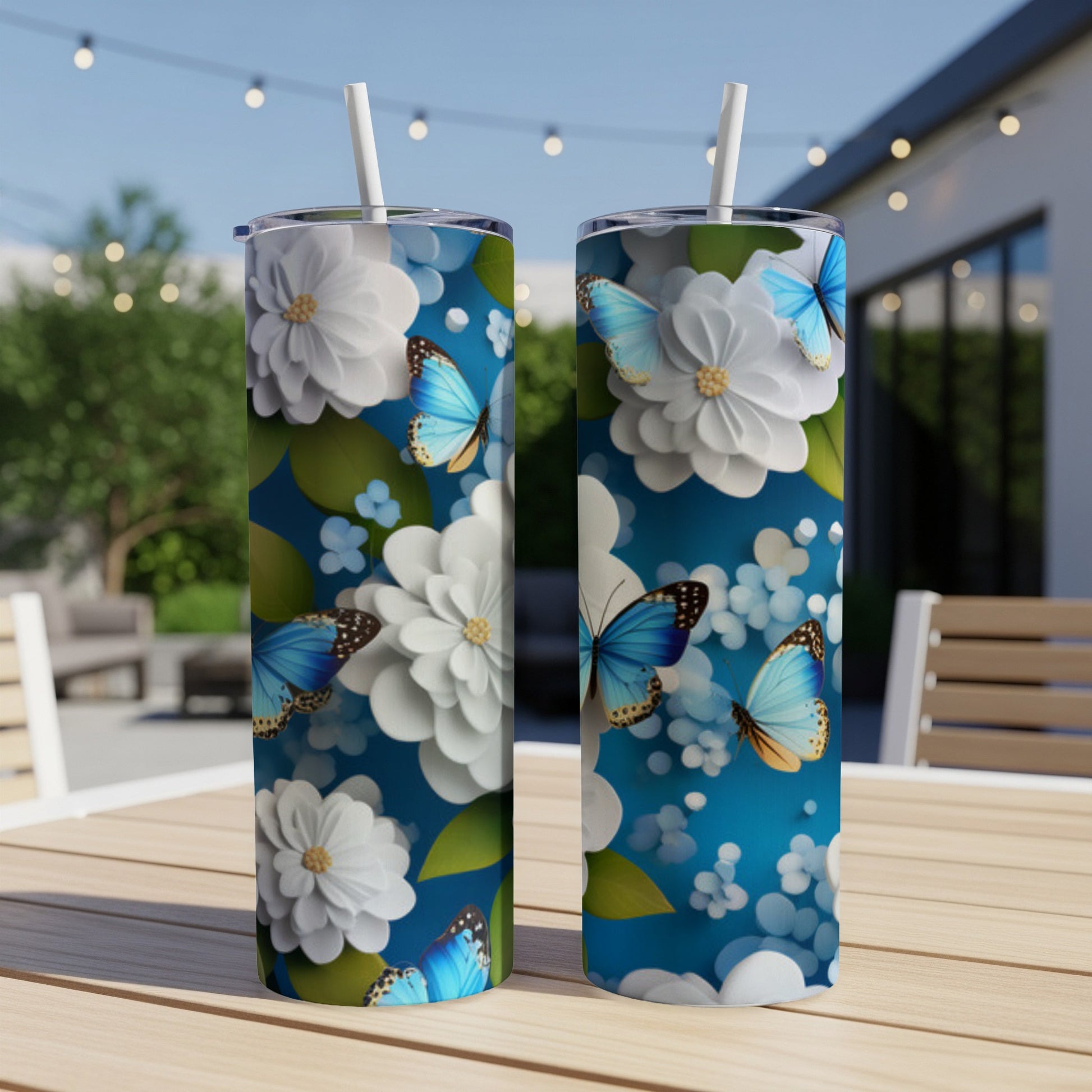 Two tall tumblers with blue butterflies and white flowers on a blue background.