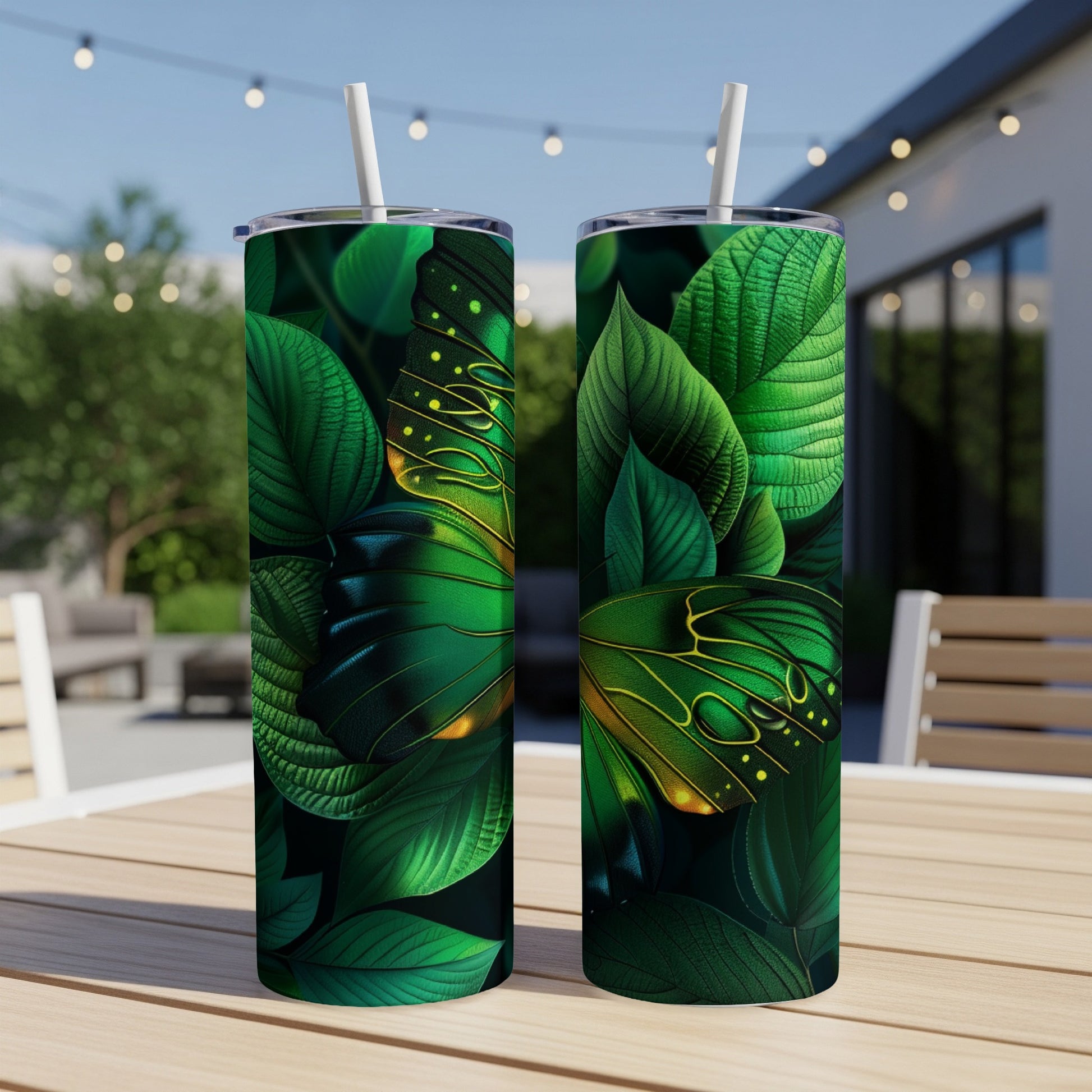 Two green tumblers with butterfly wing designs on a table.