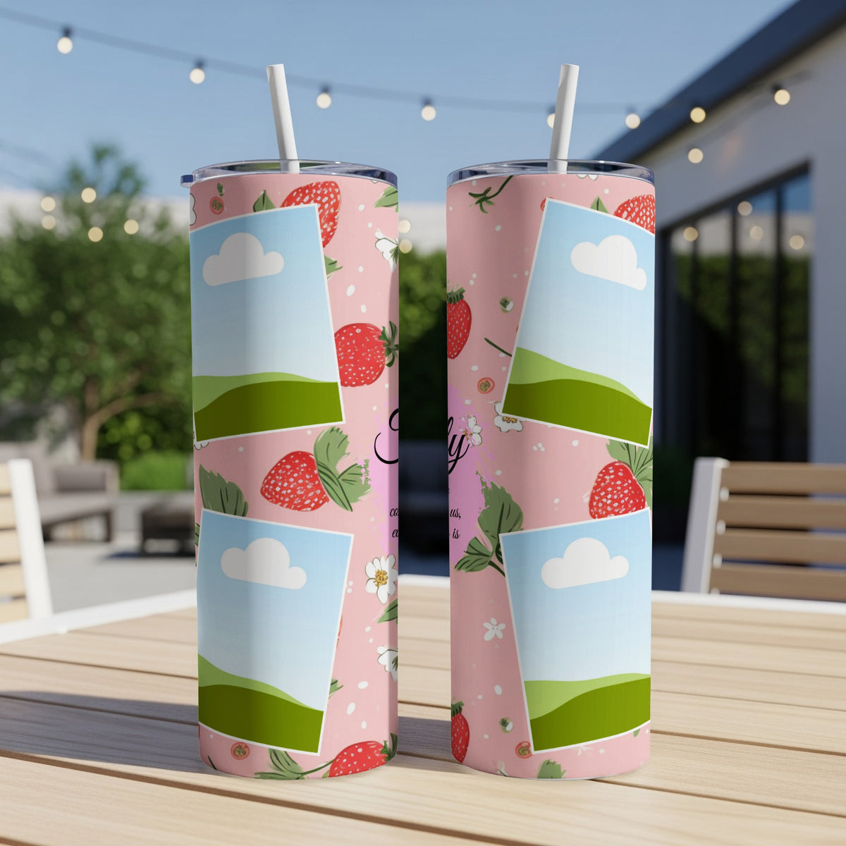 Two pink tumblers with strawberry and cloud collage designs and white straws.