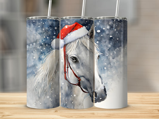 White horse wearing a Santa hat and red halter, surrounded by snow.
