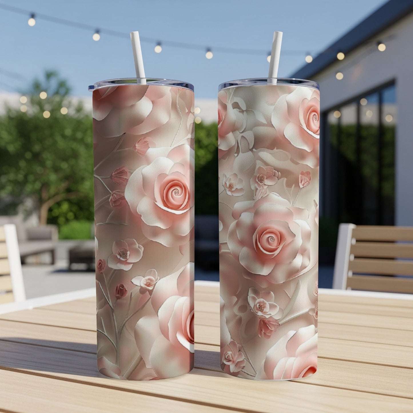 Two tall, skinny tumblers with a floral rose pattern on a wooden table.