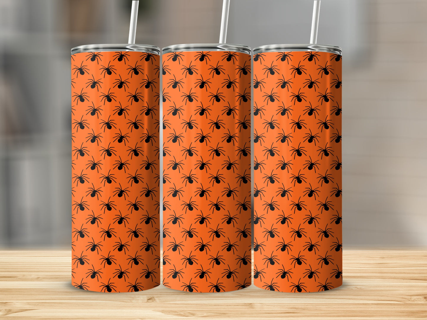 Three stainless steel tumblers with a black spider pattern on an orange background.