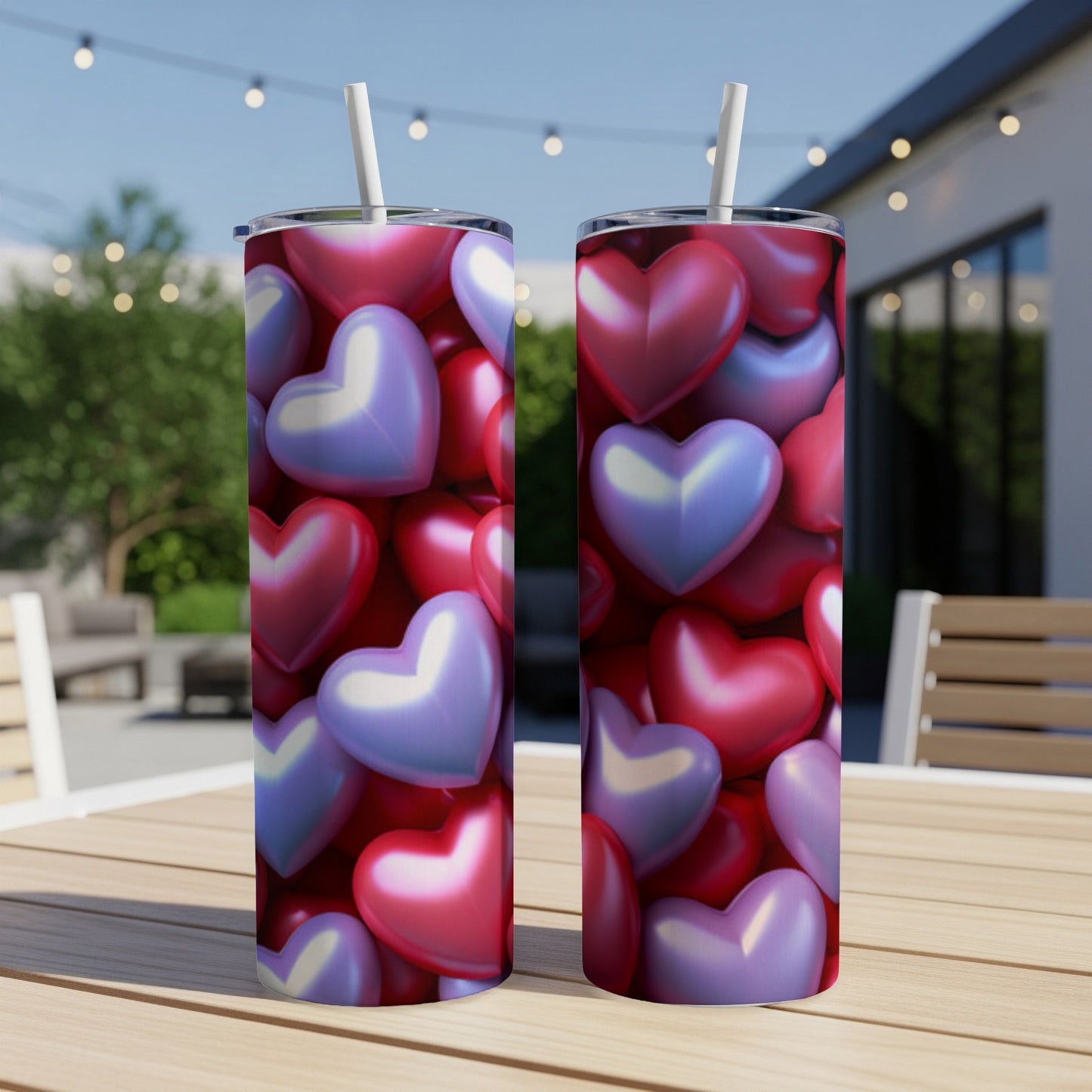 Two tumblers with heart pattern on an outdoor table.