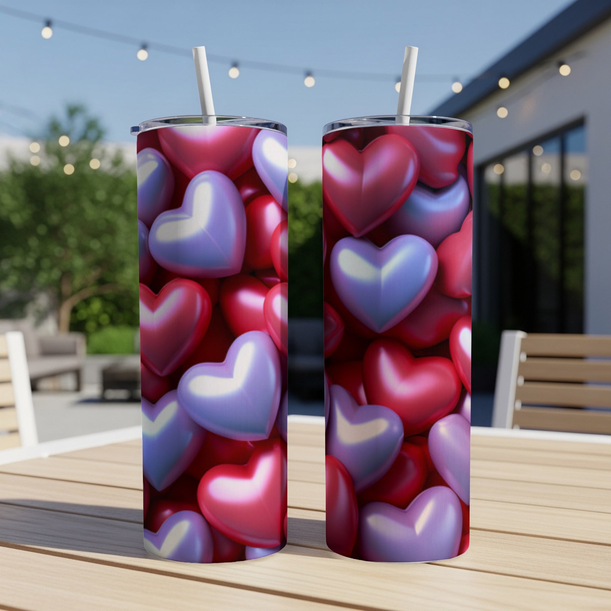 Two tumblers with heart pattern on an outdoor table.