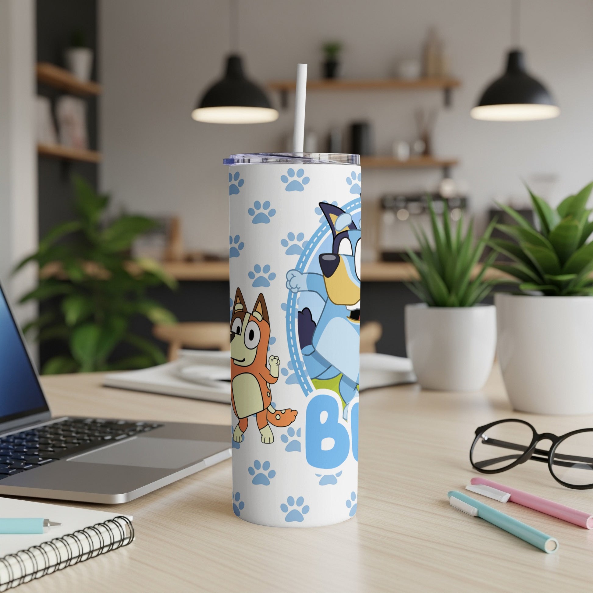Bluey and Bingo characters on a white patterned tumbler with blue paw prints.