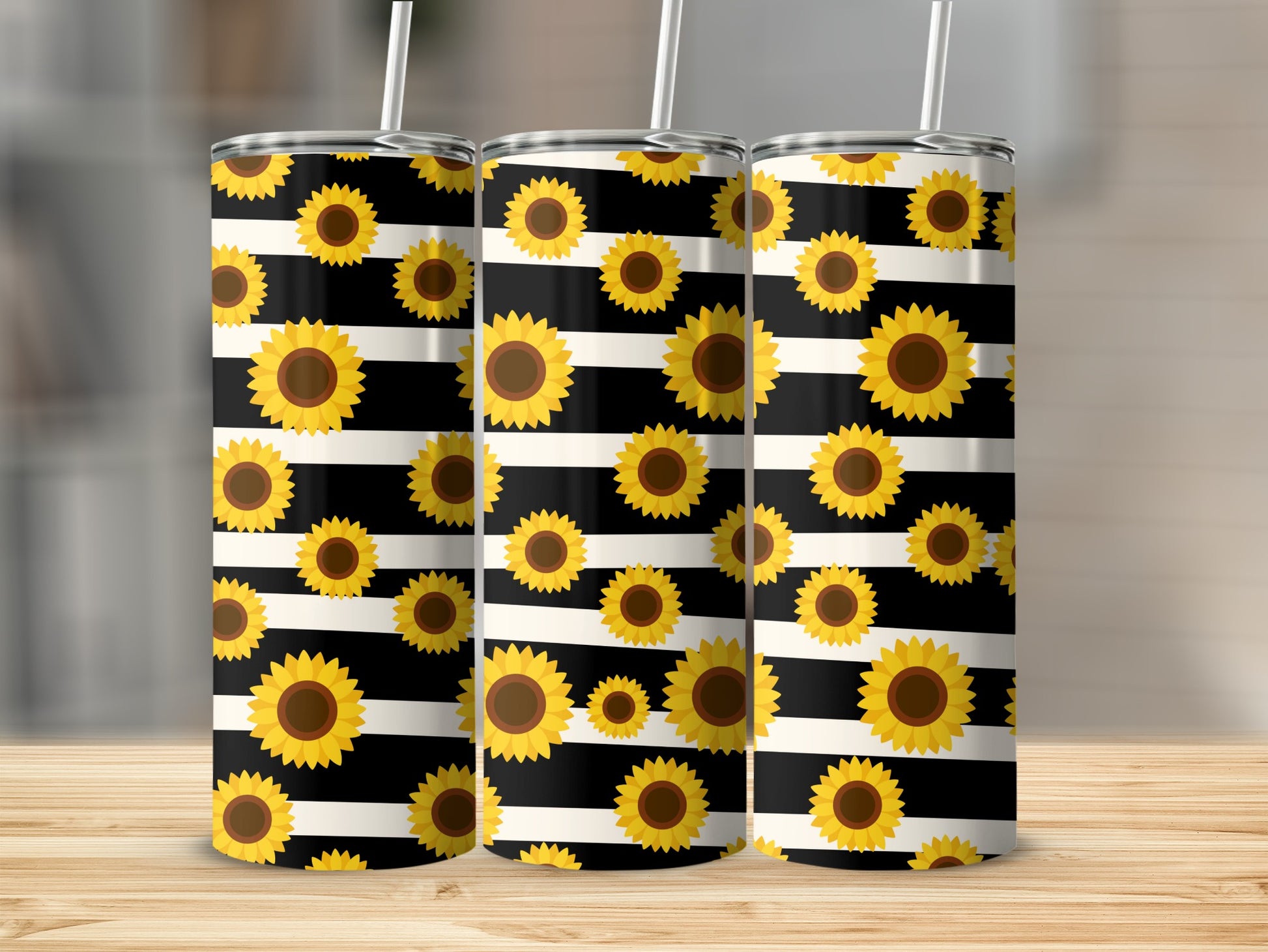 Three stainless steel tumblers with sunflowers on black and white stripes.