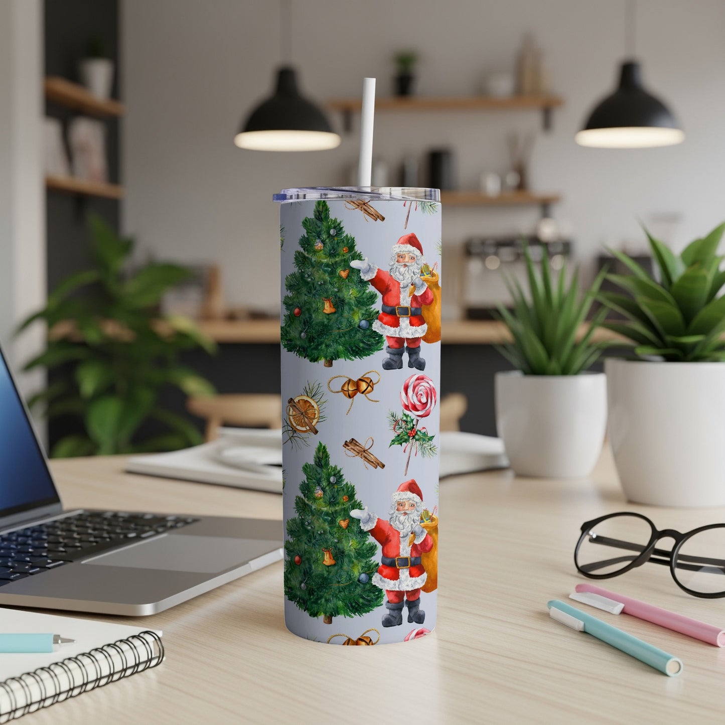 Santa Claus and Christmas tree pattern on a white tumbler with a straw.