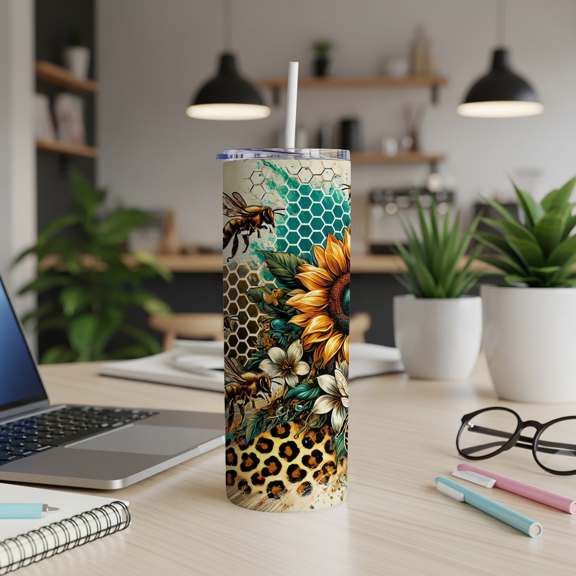 Sunflower and bee tumbler with leopard print on a desk.