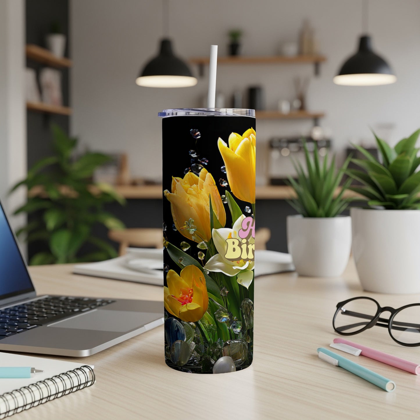 Tall tumbler with yellow tulips and "Happy Birthday" text on a desk.