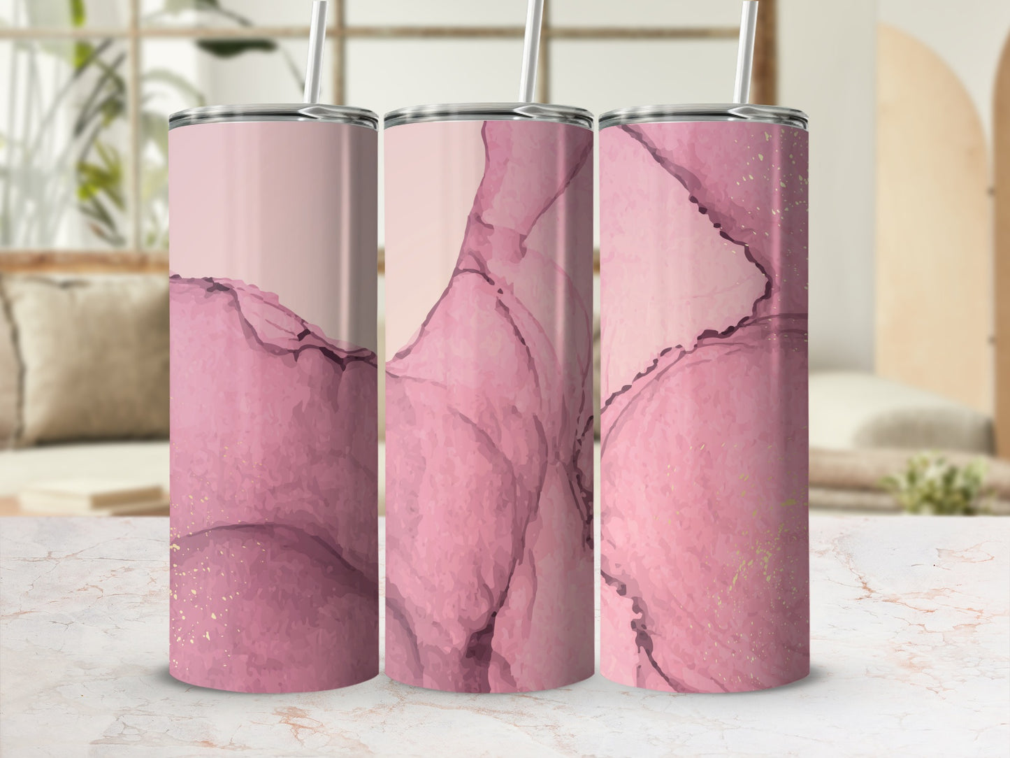 Three tumblers with pink marble and gold accents, with straws.