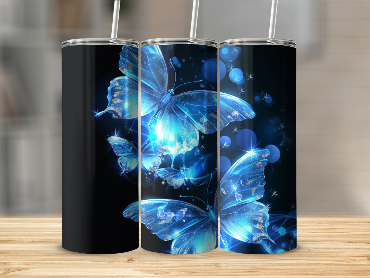Three tumblers, two with glowing blue butterflies and one solid black.