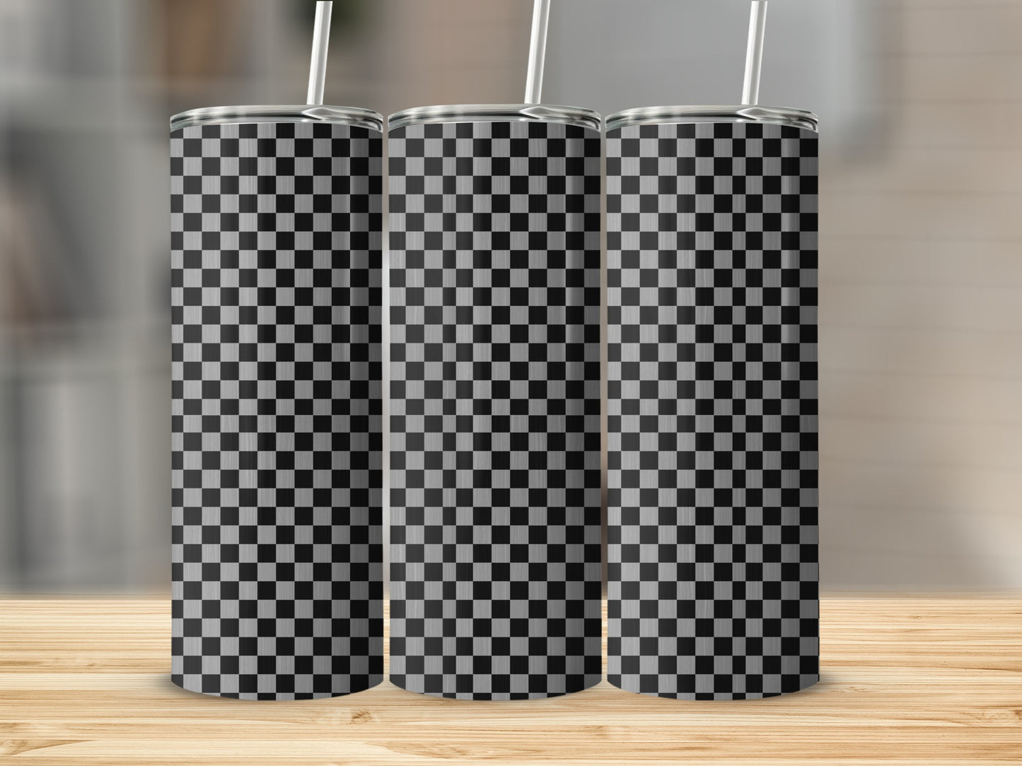 Three tumblers with a black and white checkerboard pattern stand on a wooden surface.