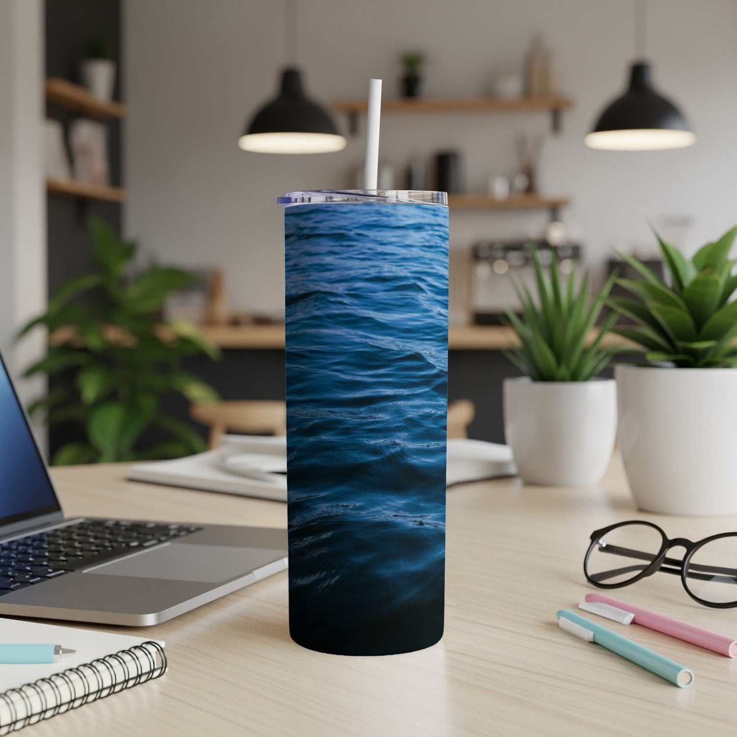 Blue water waves design on a stainless steel tumbler with straw.