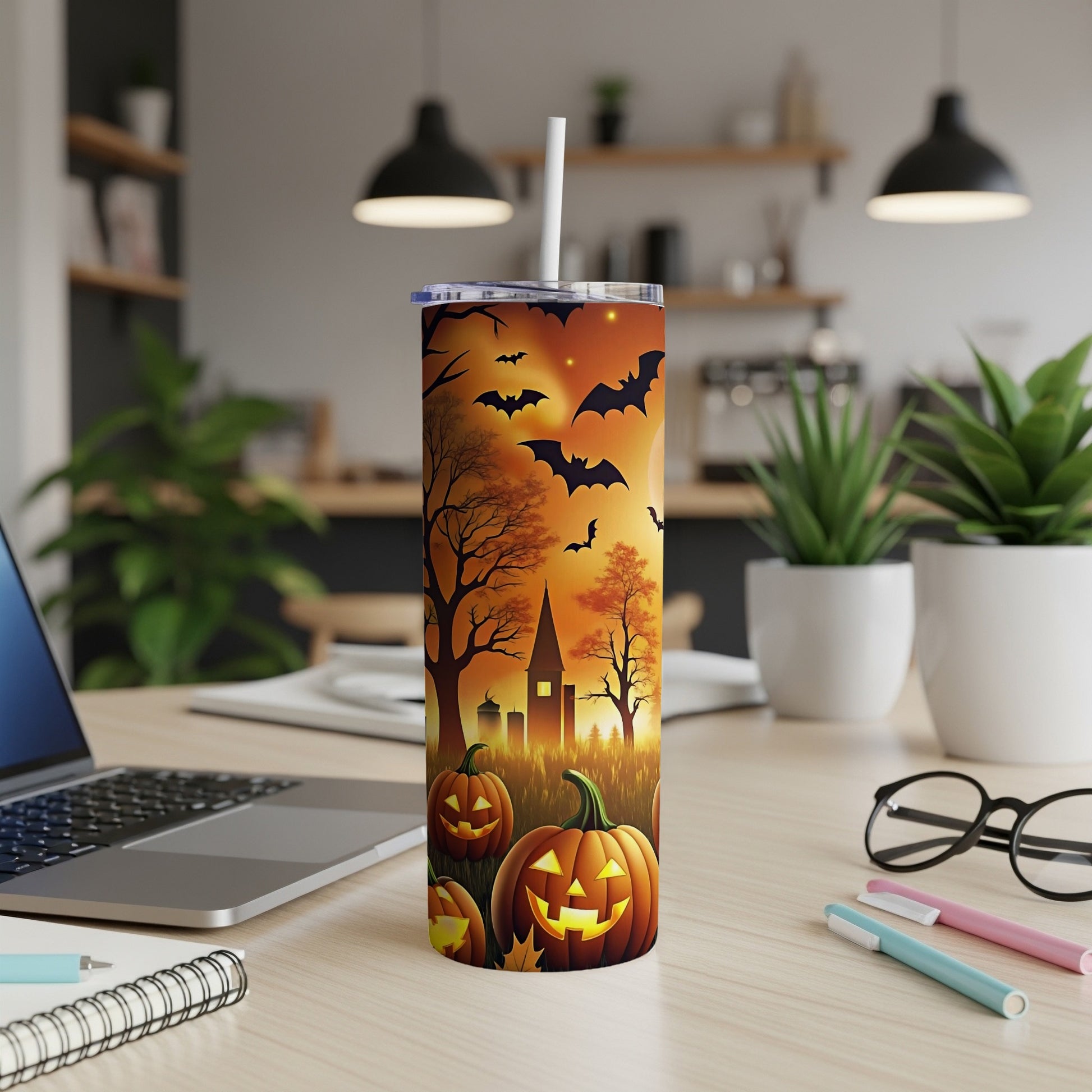 Tumbler with Halloween scene, bats, pumpkins, and spooky trees against an orange sky.