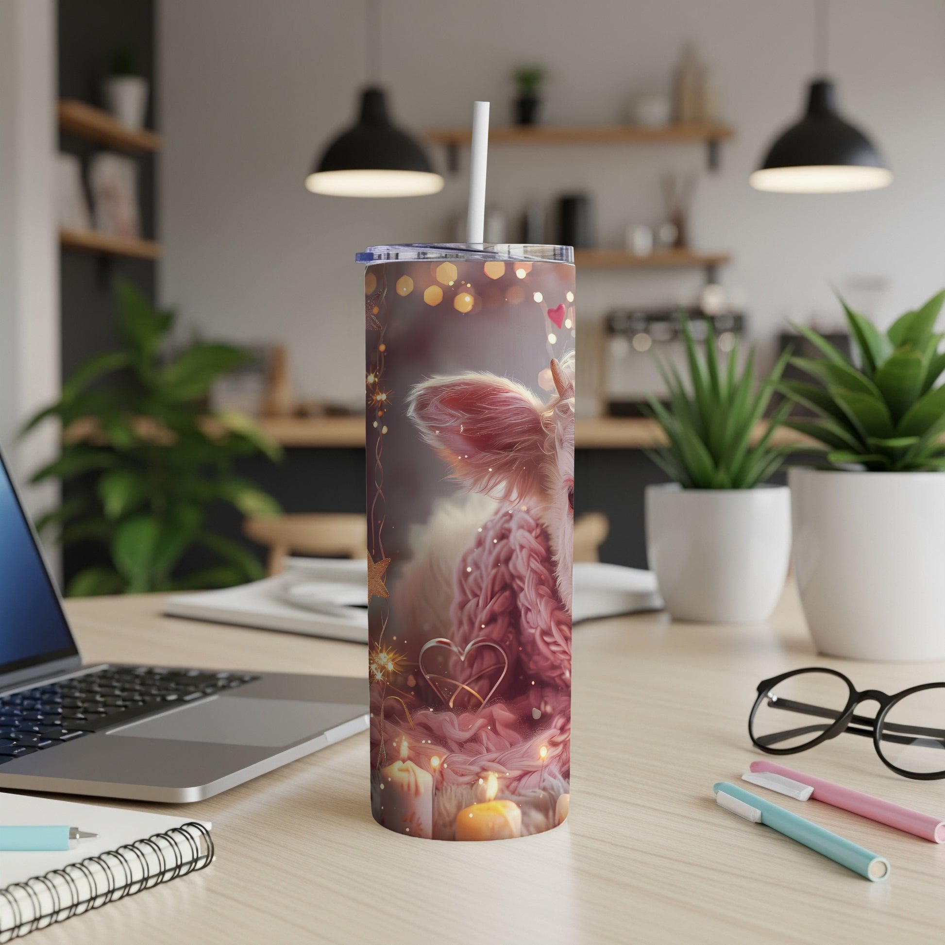 Pink fluffy cow tumbler with hearts and sparkle accents on a desk.
