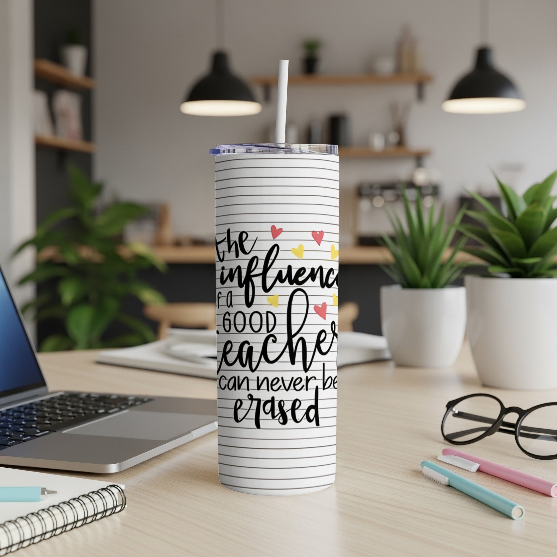 Striped tumbler with "The influence of a good teacher can never be erased" text.