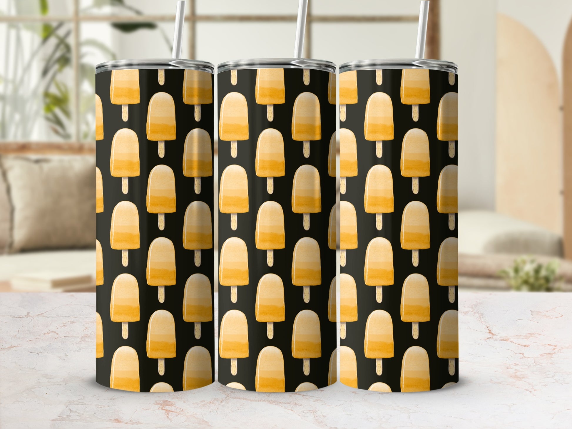 Three tumblers with a pattern of orange popsicle ice cream on a black background.