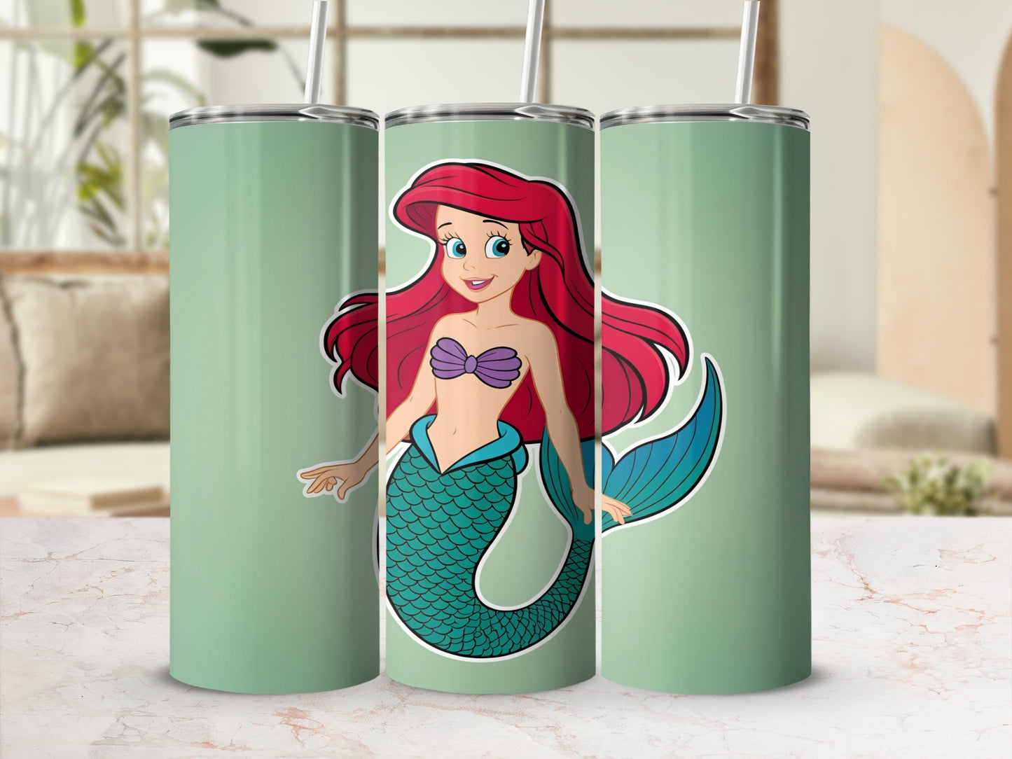 Ariel the mermaid with red hair and green tail on a mint green tumbler.
