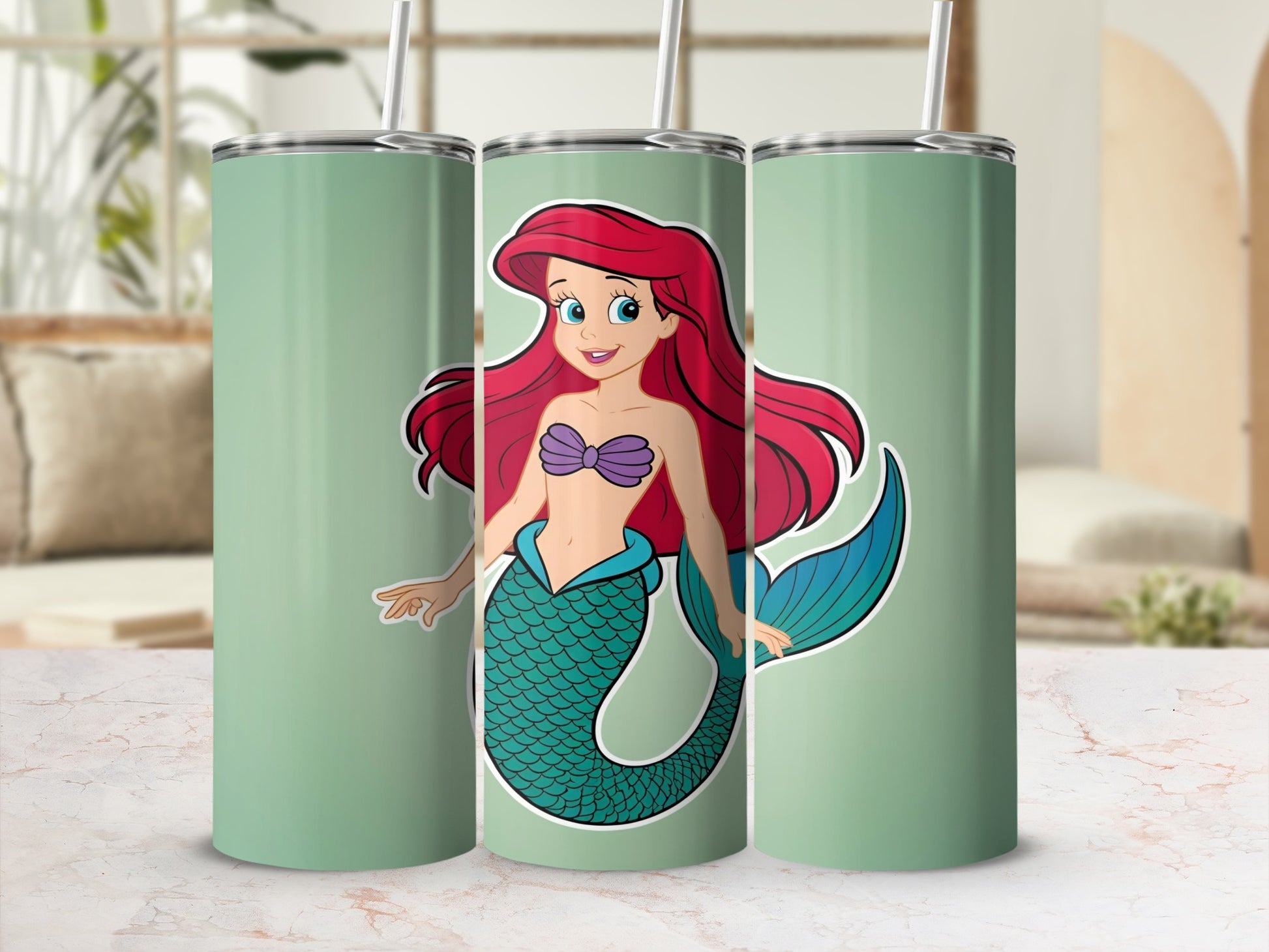Ariel the mermaid with red hair and green tail on a mint green tumbler.