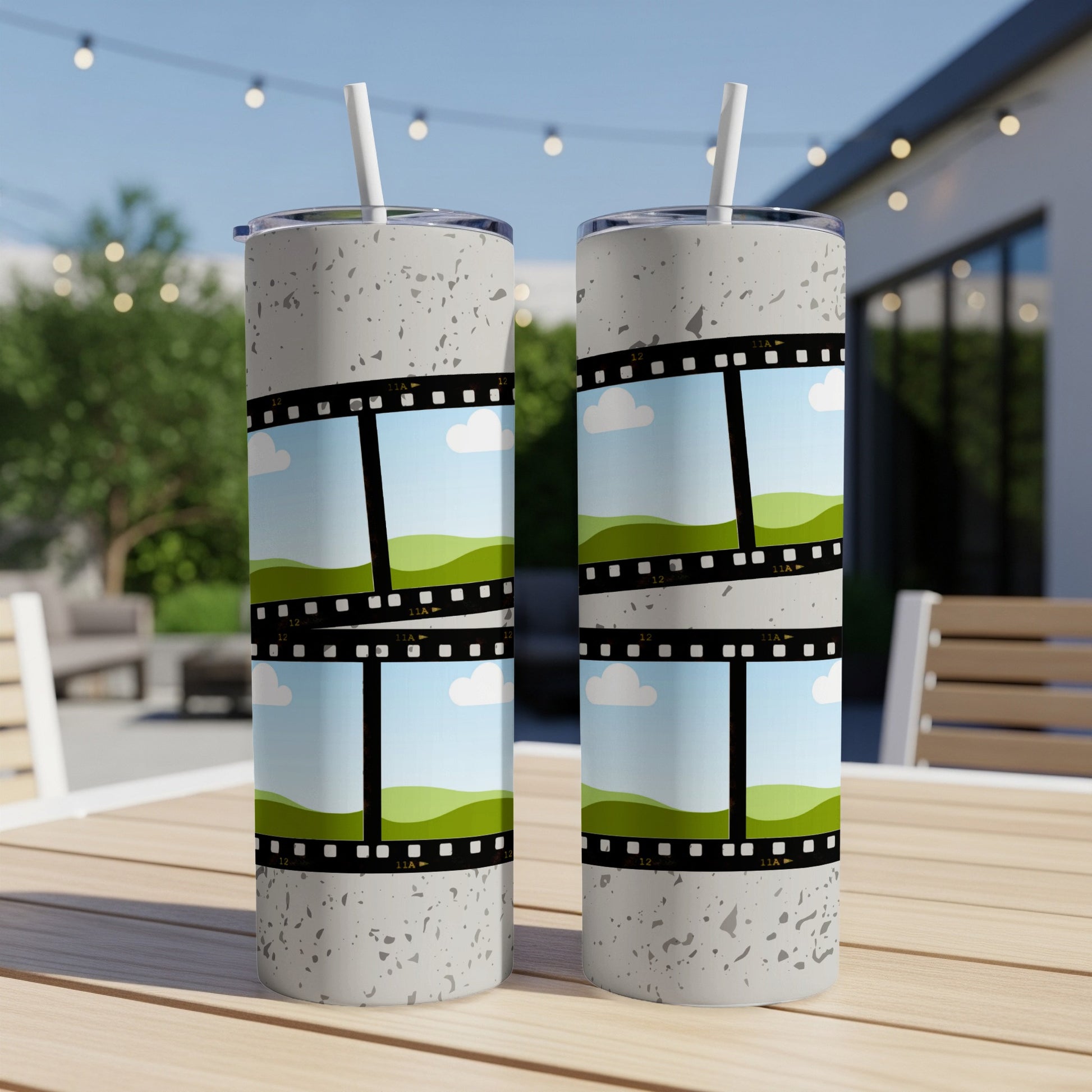 Two tumblers with a film strip design featuring cartoon landscapes and clouds.