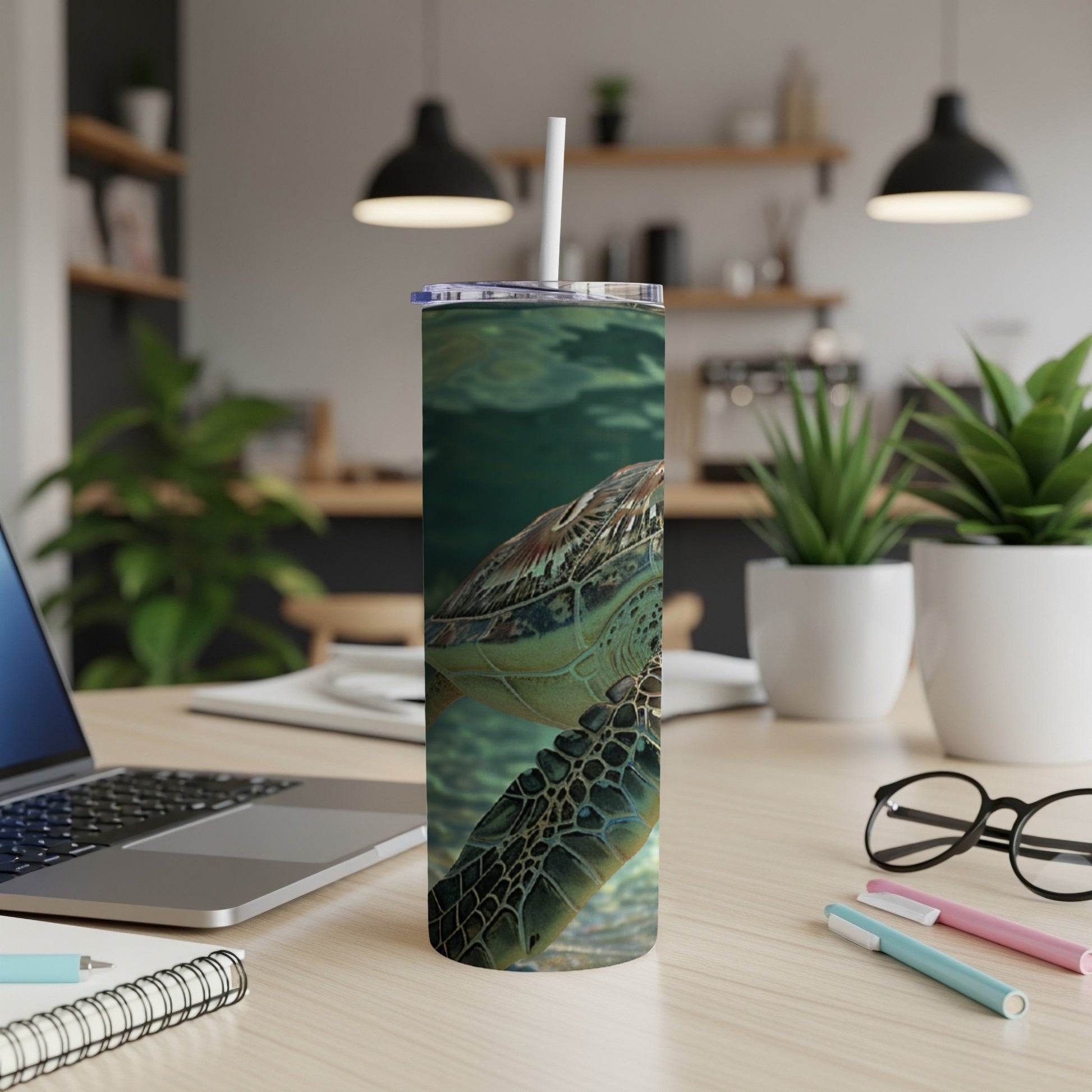 Sea turtle swimming underwater on a patterned tumbler with a straw.