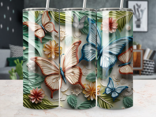 Three tumblers with butterflies and floral cutouts on a marble surface.