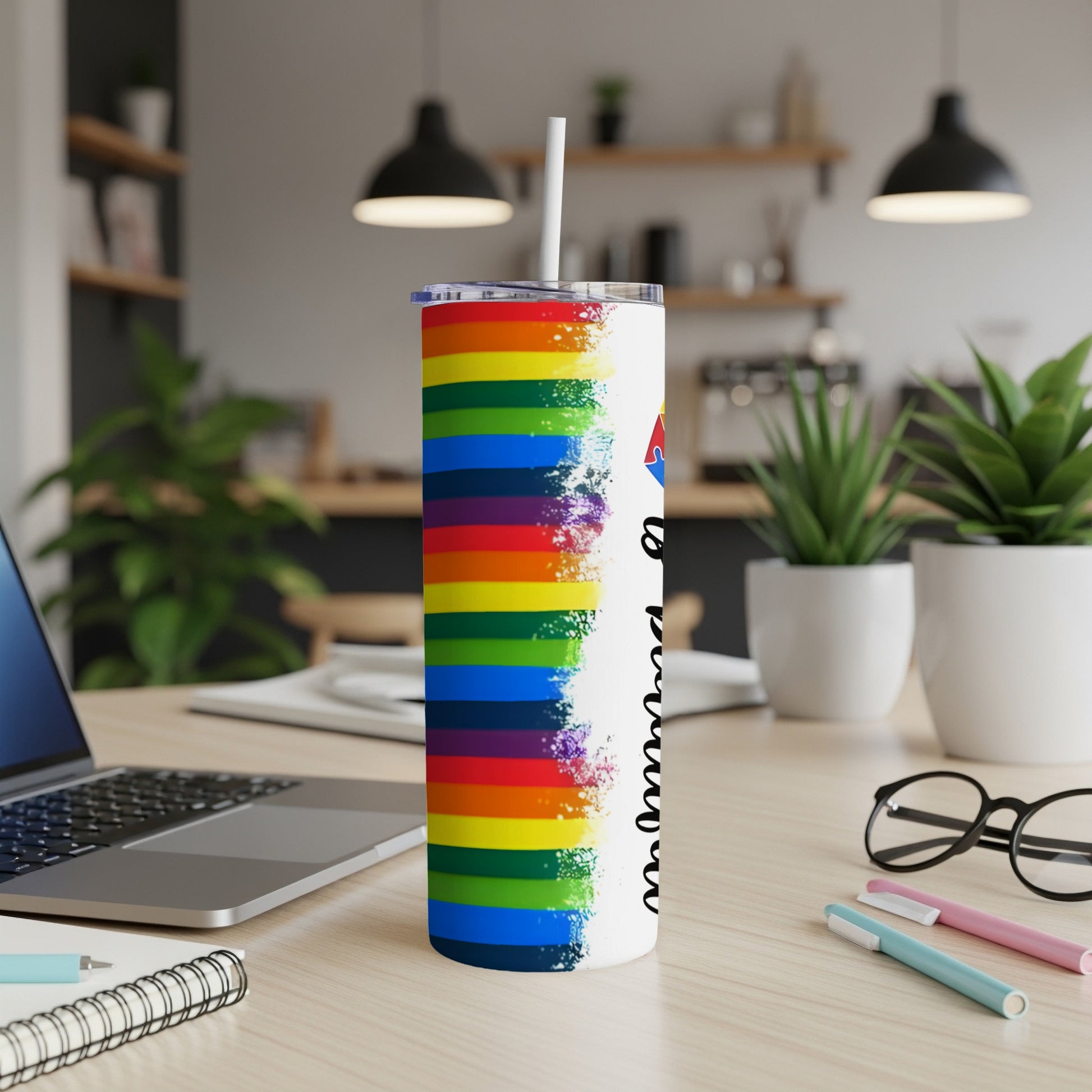 Rainbow stripe tumbler with text "Pride" in cursive, on a desk.