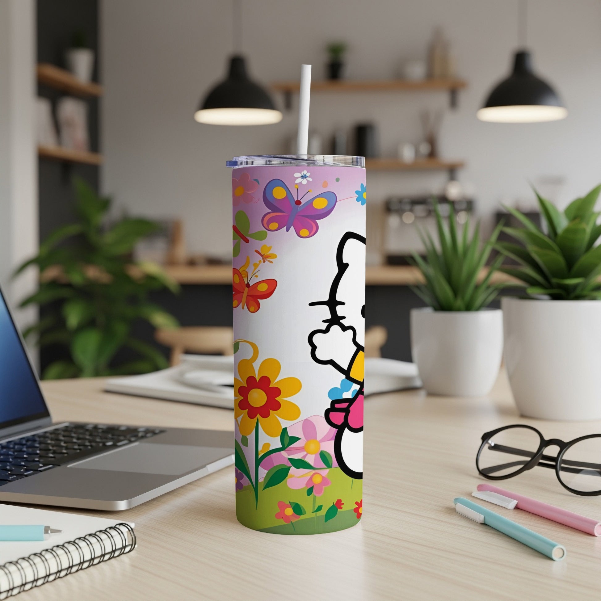 White tumbler with cartoon cat, butterflies, and flowers, featuring a straw.