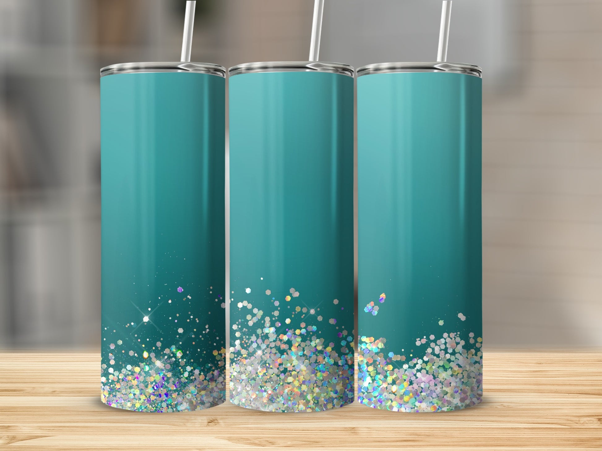 Three teal tumblers with glitter ombre design and white straws.