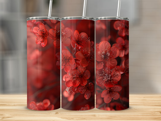 Three tumblers with a red floral pattern, each with a white straw.