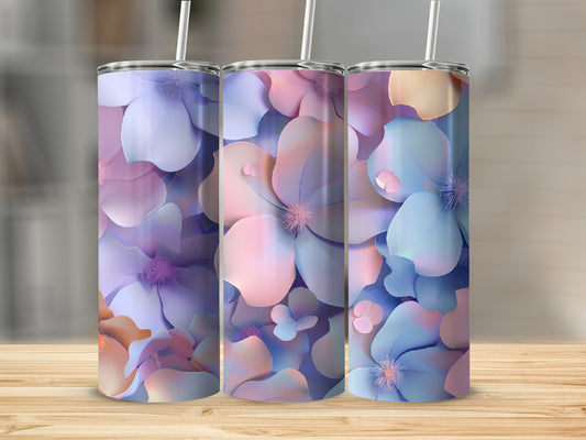 Three floral patterned tumblers with straws on a wooden surface.