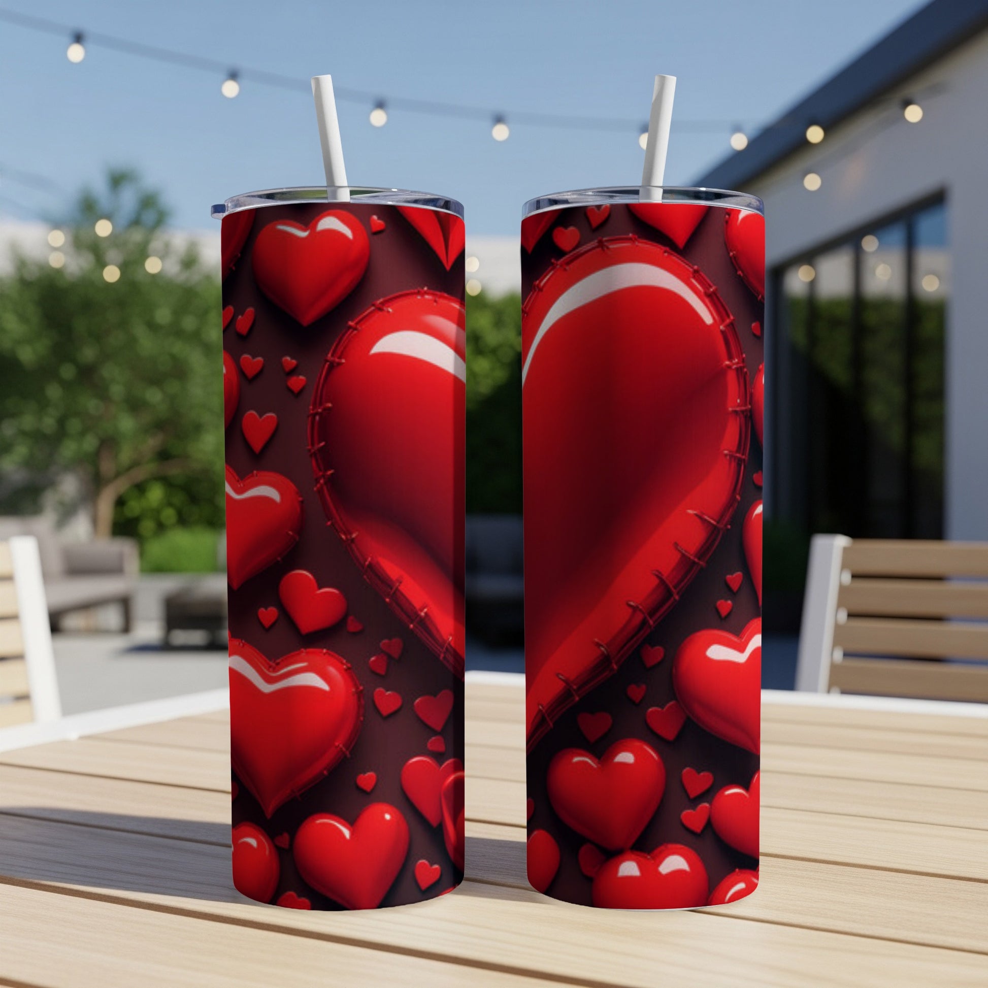 Two tumblers with a red heart pattern displayed on a table outdoors.