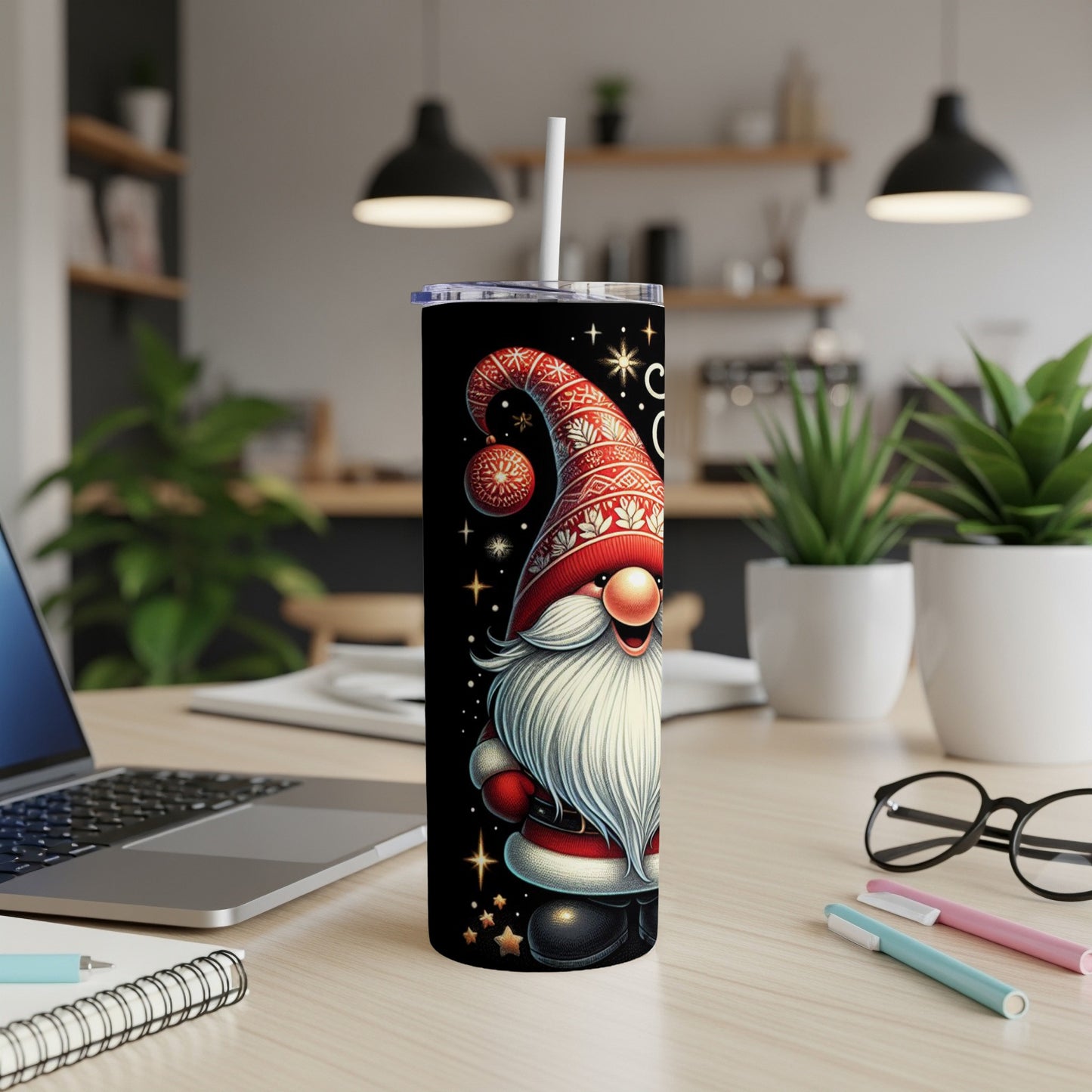 Christmas gnome tumbler with a straw on a desk.