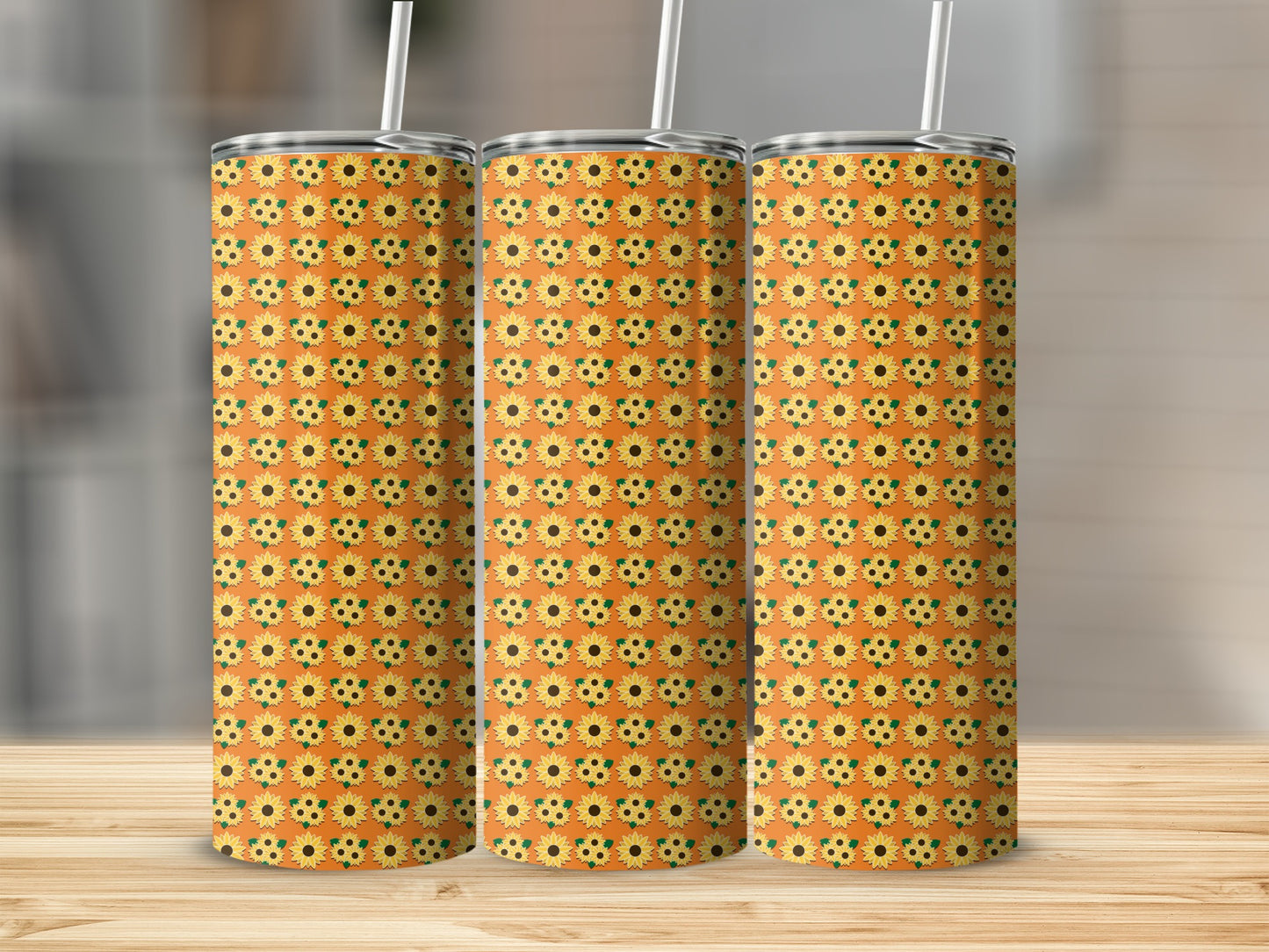 Three tumblers with a repeating sunflower pattern on an orange background.