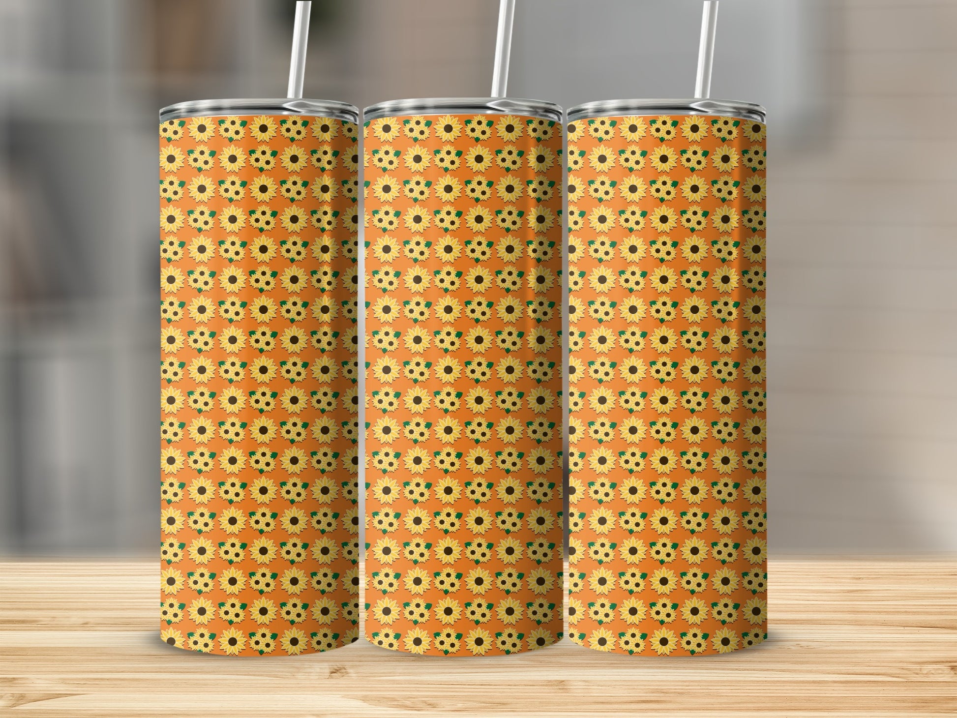 Three tumblers with a repeating sunflower pattern on an orange background.